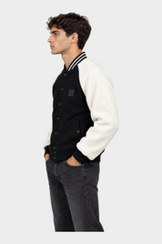 Modello indossa giubbino bomber Follower SRL nero con maniche in pile bianco e dettagli a righe sul colletto