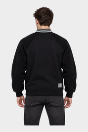 Vista posteriore del giubbino bomber nero Follower SRL con maniche in tessuto teddy e colletto a righe bianche