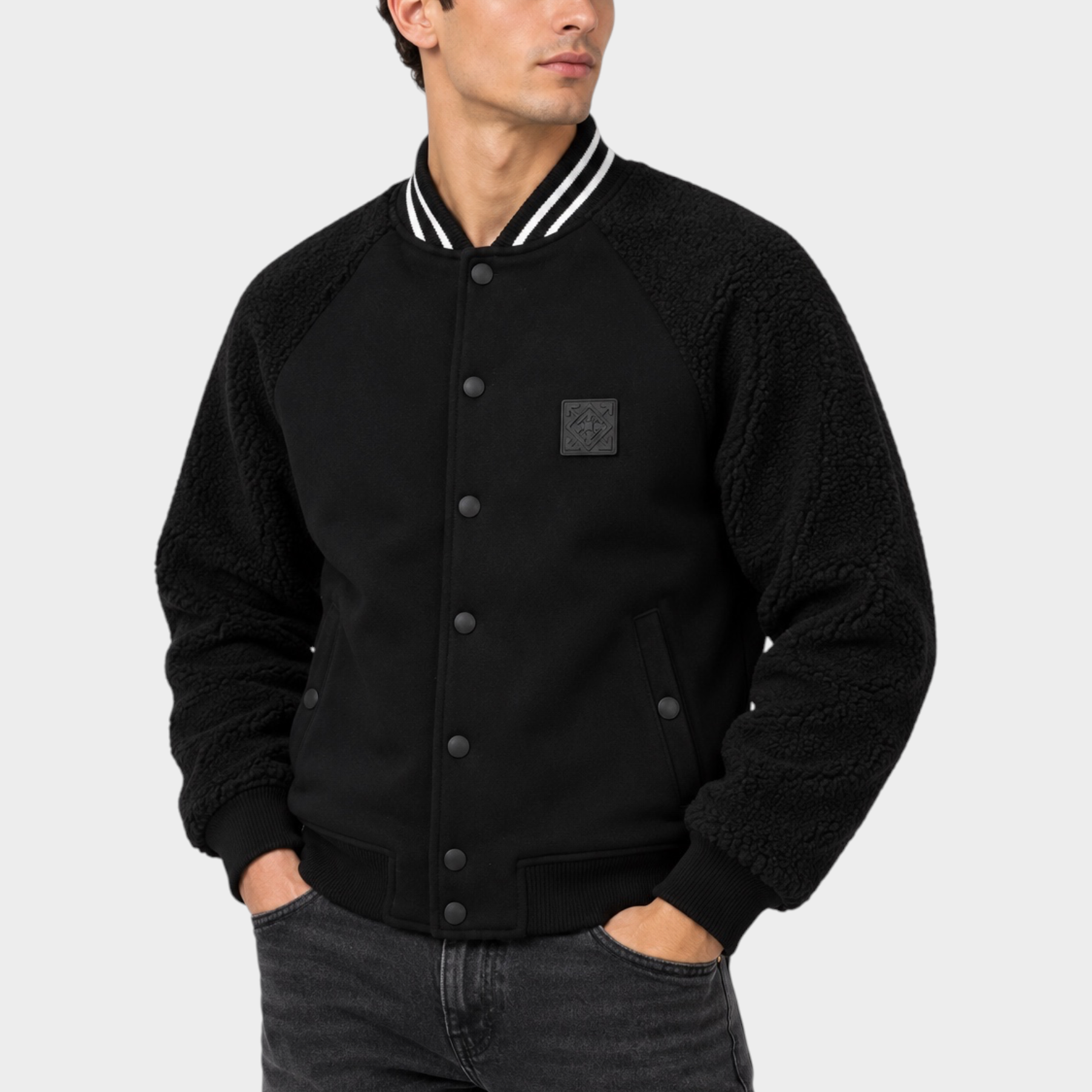 Modello indossa un giubbino bomber nero Follower SRL con maniche in tessuto teddy e chiusura a bottoni a pressione