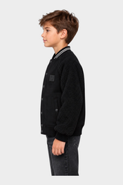 Ragazzo indossa giubbino bomber nero Follower SRL con maniche in tessuto teddy e chiusura a bottoni