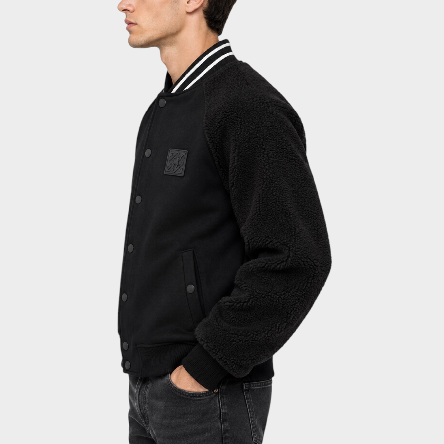 Modello indossa giubbino bomber nero Follower SRL con maniche in tessuto teddy e chiusura a bottoni a pressione