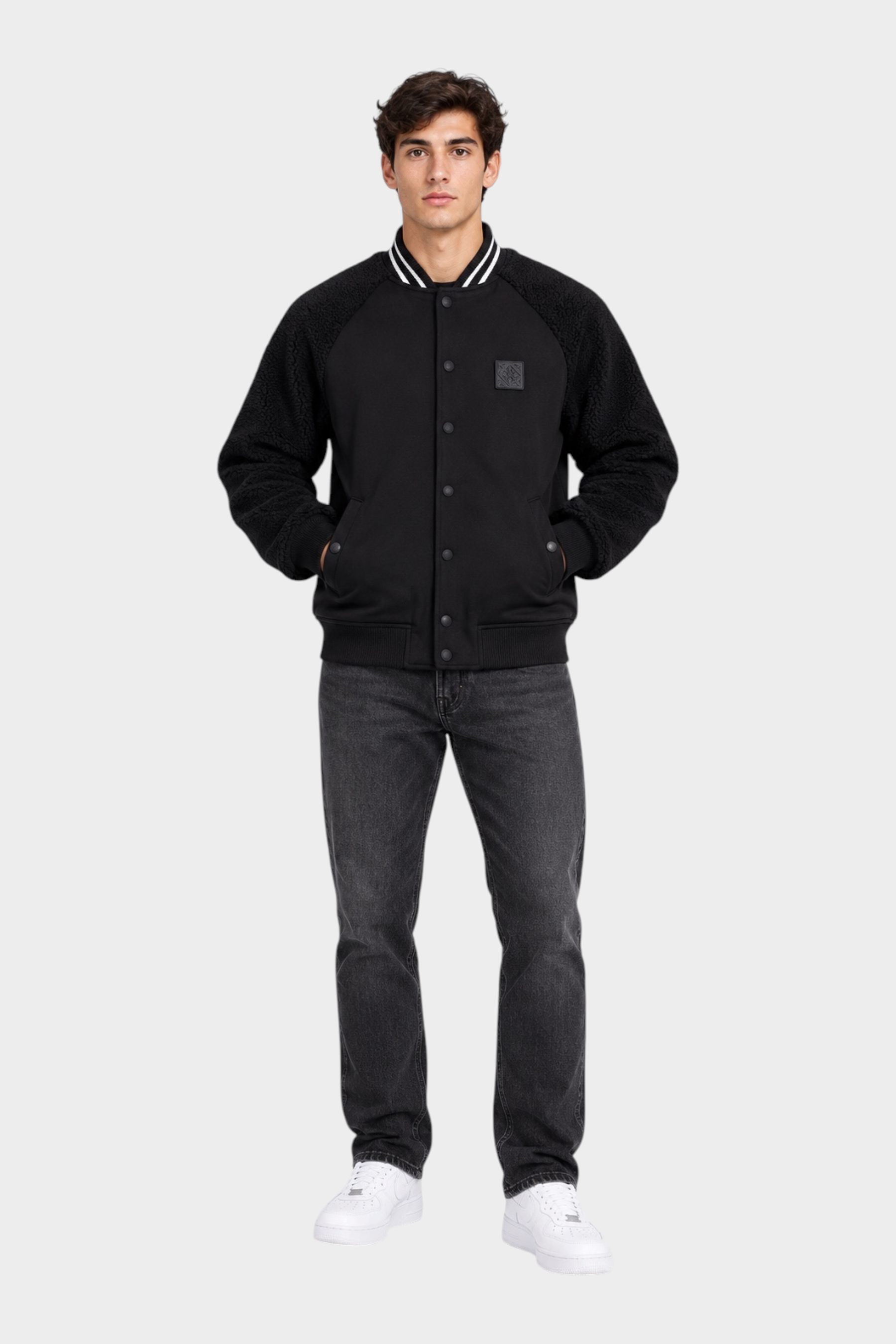 Modello indossa giubbino bomber nero Follower SRL con maniche in tessuto teddy e chiusura a bottoni