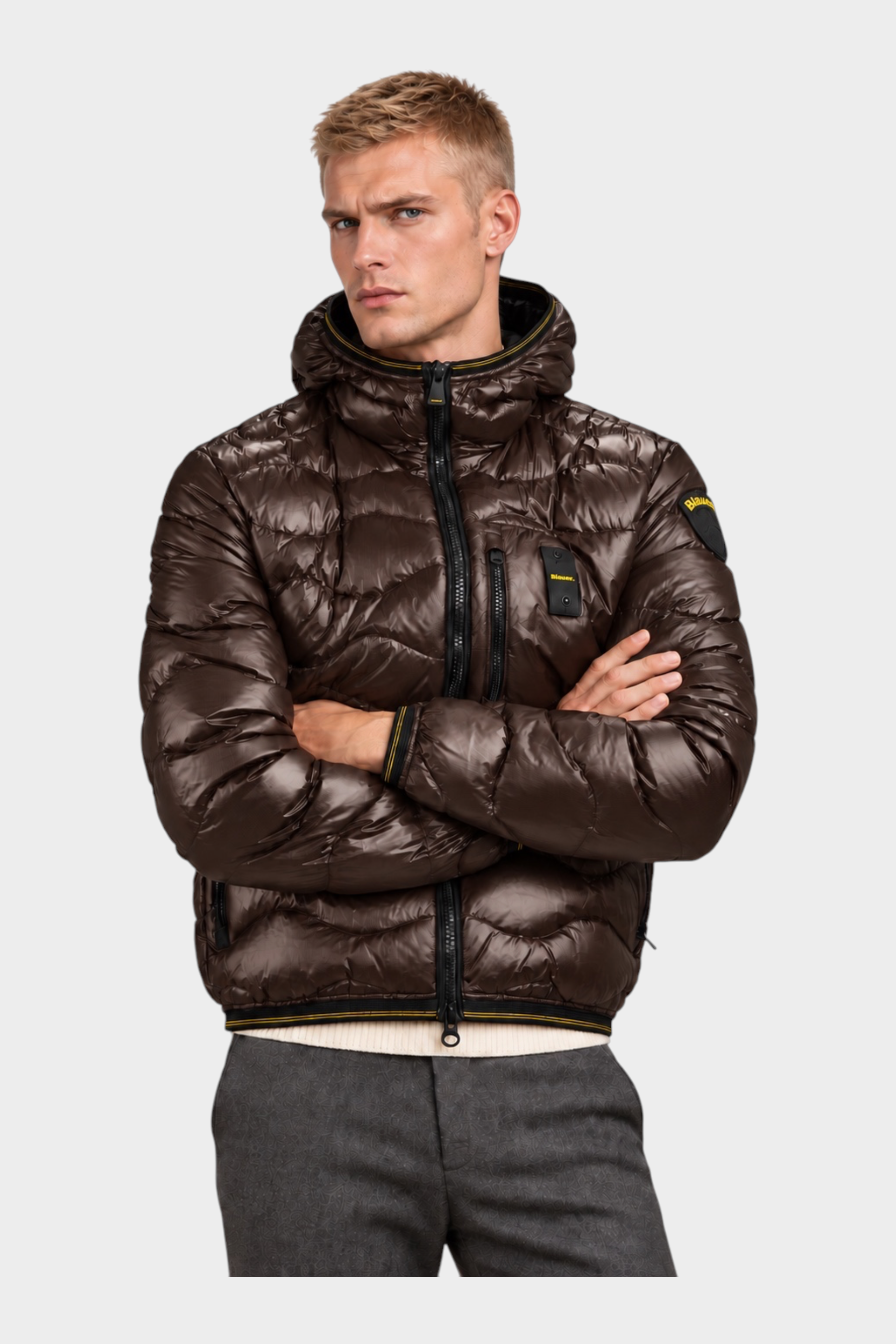 Modello indossa giubbino trapuntato marrone Follower SRL con cappuccio, motivo a onde e logo Blauer sulla manica