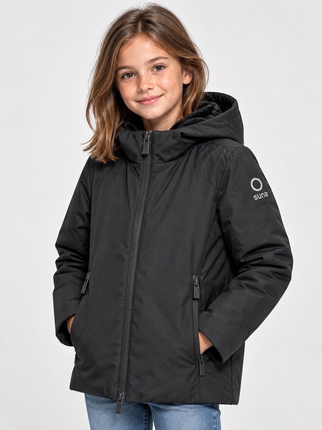 Bambina che indossa il giubbino nero Aurelia Velour di Follower SRL con cappuccio e logo SUNS BOARDS sulla manica