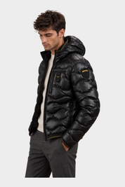 Modello indossa giubbino trapuntato nero con cappuccio Follower SRL, design a onde lucido con logo Blauer sul braccio