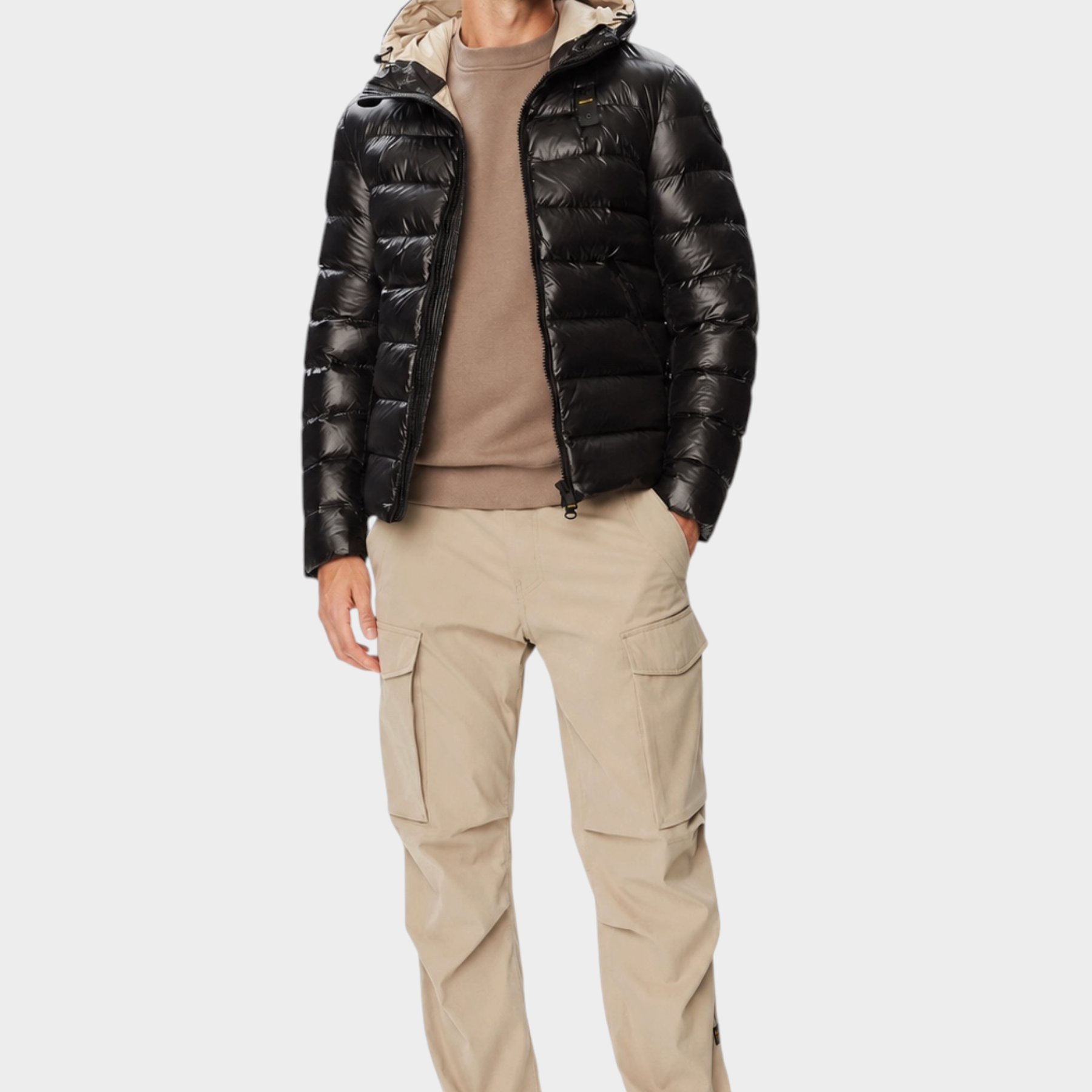 Modello indossa giubbino nero lucido con cappuccio Follower SRL, abbinato a maglia beige e pantaloni cargo