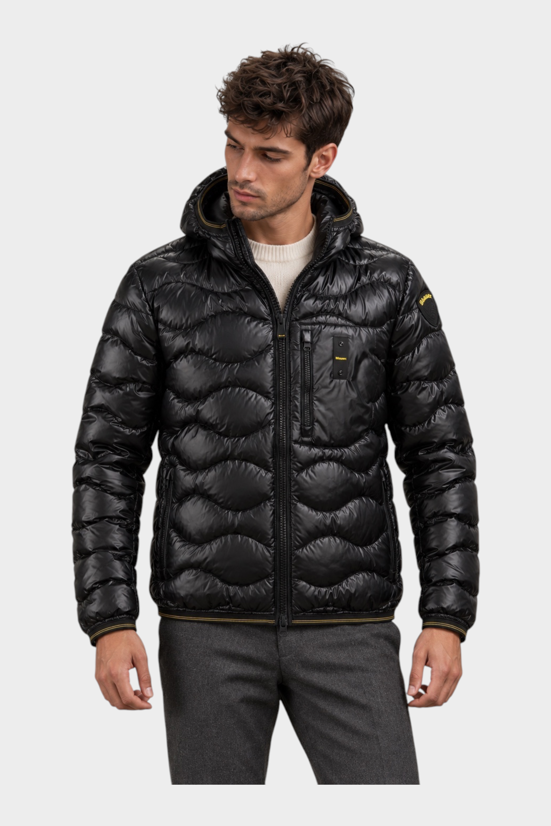 Modello indossa giubbino Follower SRL nero trapuntato a onde con cappuccio e chiusura zip frontale