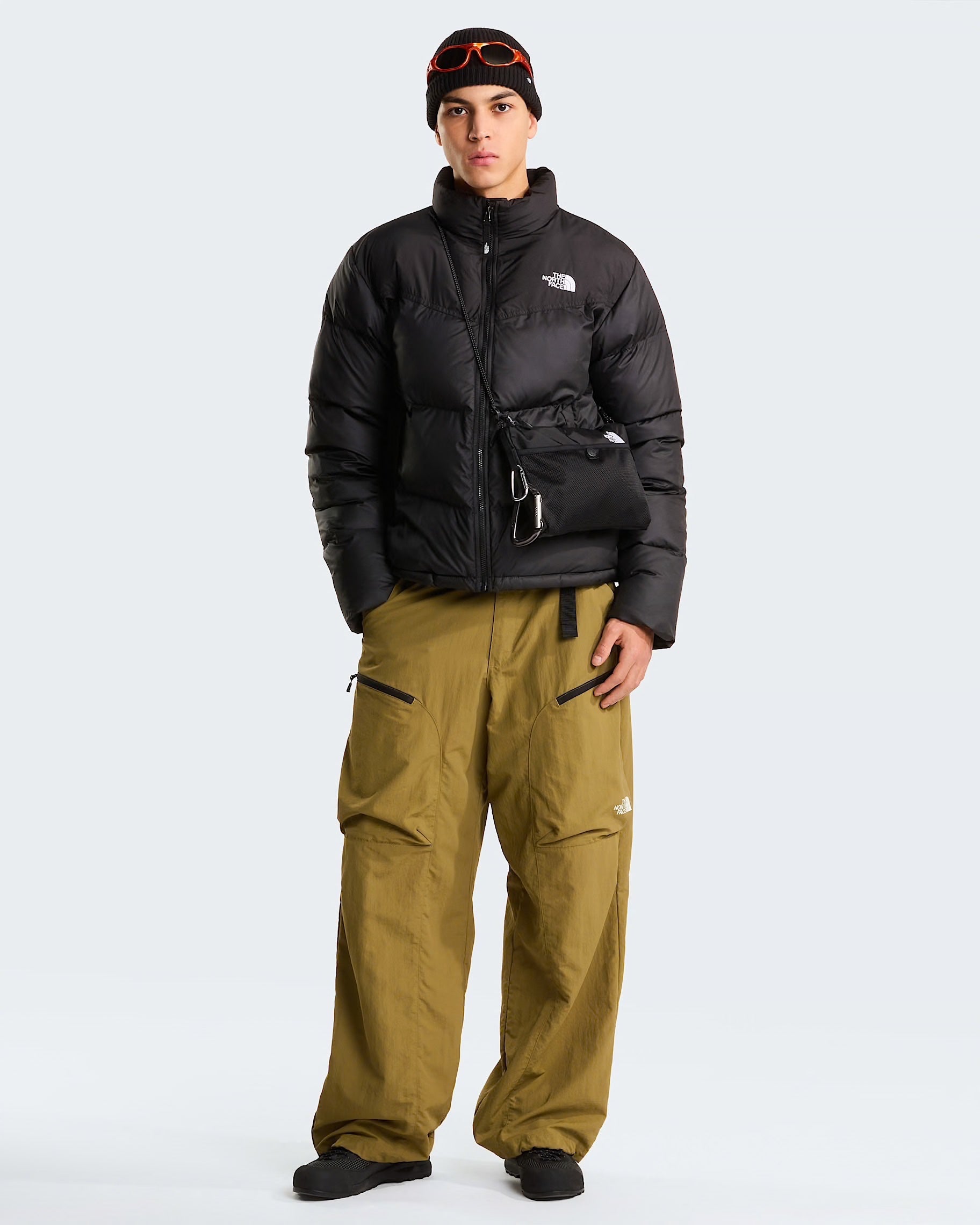 Modello Follower SRL indossa giubbino nero The North Face Saikuru con tecnologia WindWall e pantaloni cargo color kaki
