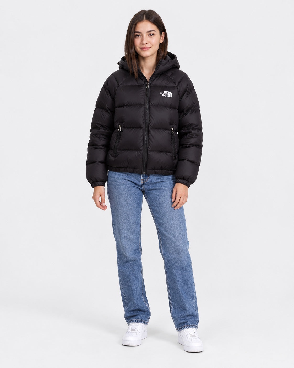 Modella indossa giubbino nero con cappuccio Hydrenalite™ The North Face proposto da Follower SRL con jeans blu