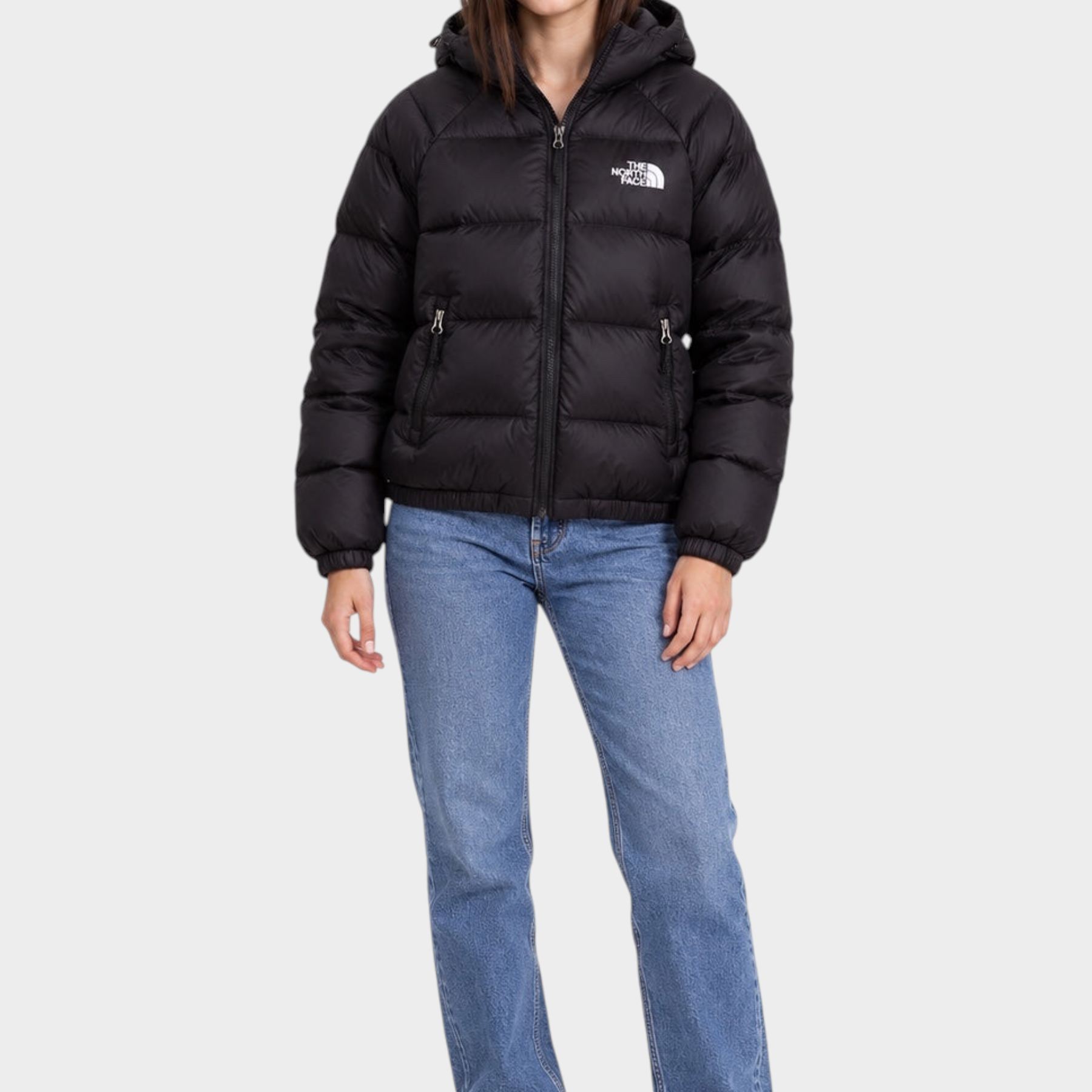 Modella indossa giubbino nero con cappuccio Hydrenalite™ The North Face proposto da Follower SRL con jeans blu