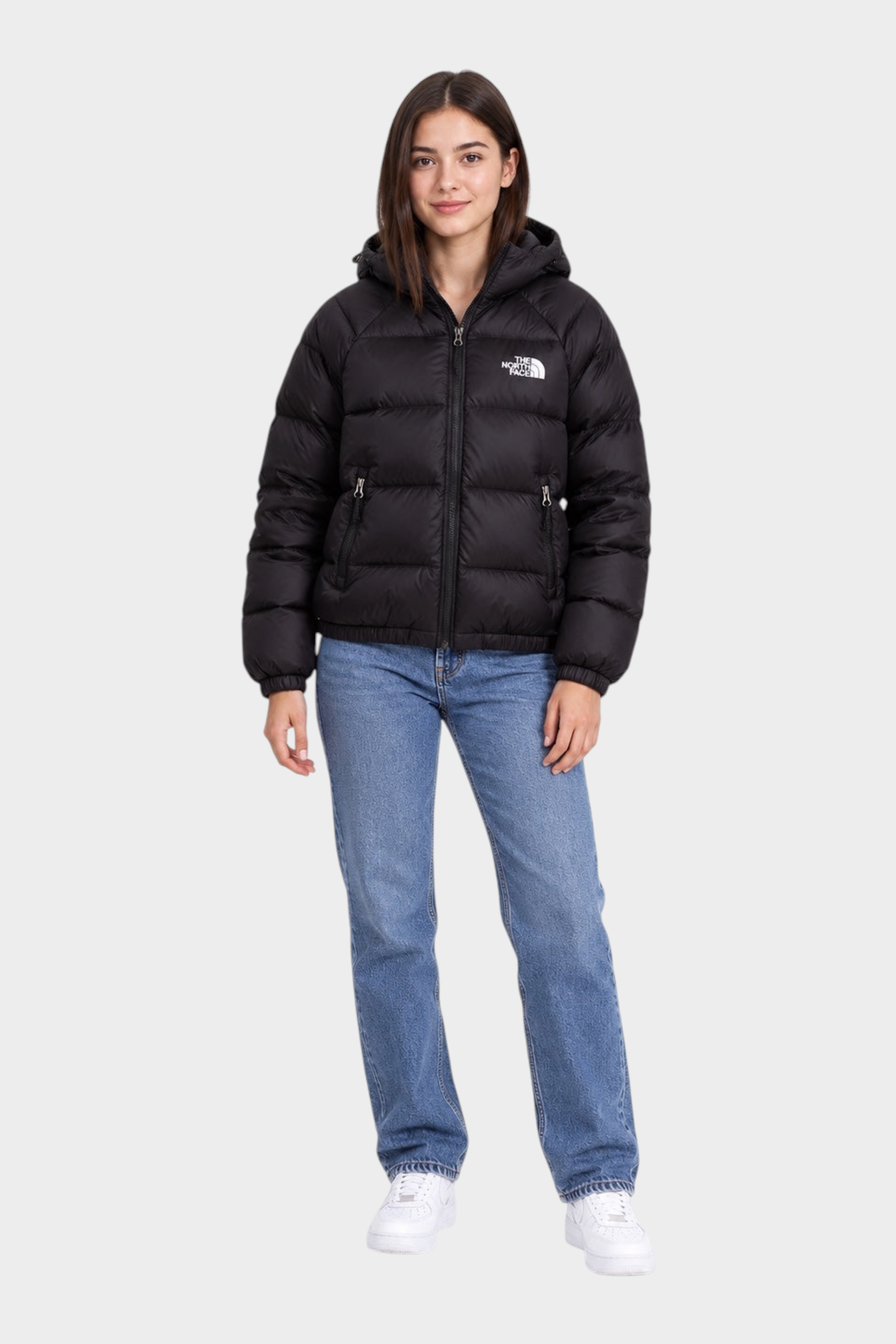 Modella indossa giubbino nero con cappuccio Hydrenalite™ The North Face proposto da Follower SRL con jeans blu