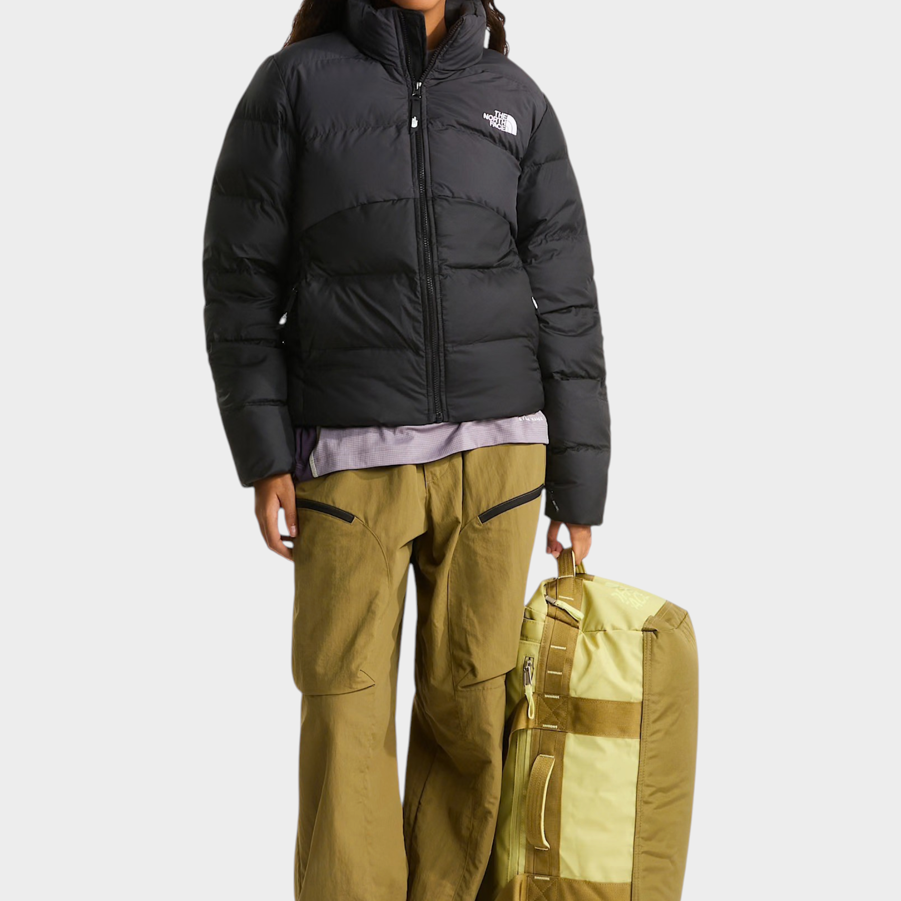 Modella indossa giubbino nero imbottito The North Face Saikuru con pantaloni cargo beige e borsa Follower SRL