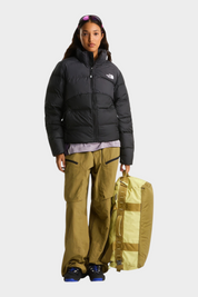 Modella indossa giubbino nero imbottito The North Face Saikuru con pantaloni cargo beige e borsa Follower SRL