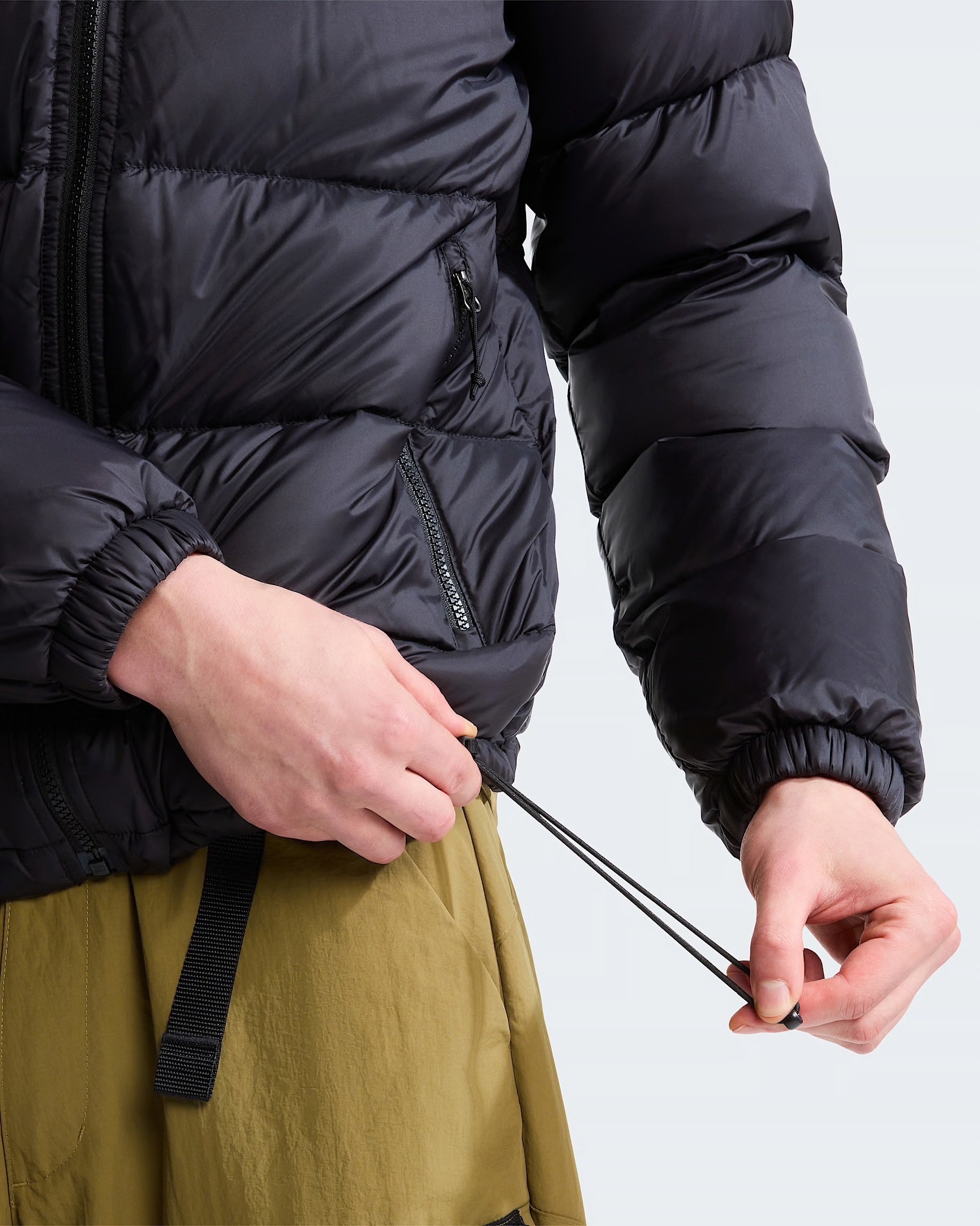 Giubbino piumino nero con cappuccio Follower SRL, dettaglio regolazione coulisse in vita e tasche con zip