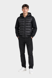 Modello indossa giubbino Follower SRL nero in piumino e nylon con cappuccio, stile casual su sfondo bianco