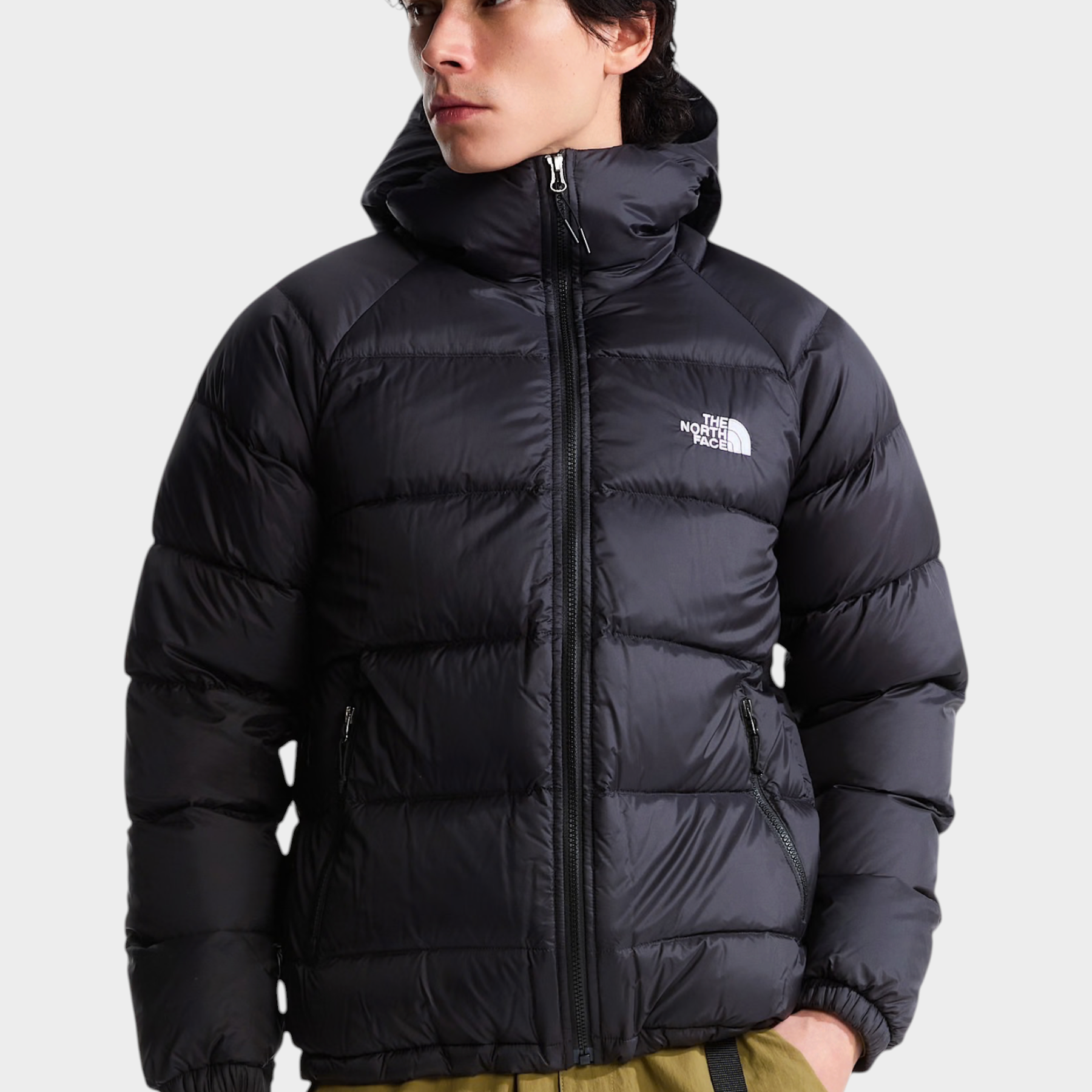 Modello indossa giubbino nero con cappuccio in piumino Hydrenalite di Follower SRL con logo The North Face sul petto