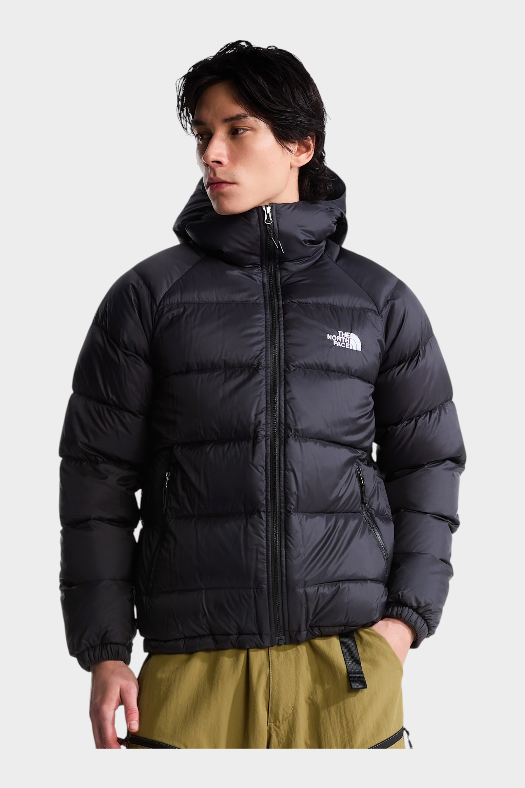 Modello indossa giubbino nero con cappuccio in piumino Hydrenalite di Follower SRL con logo The North Face sul petto