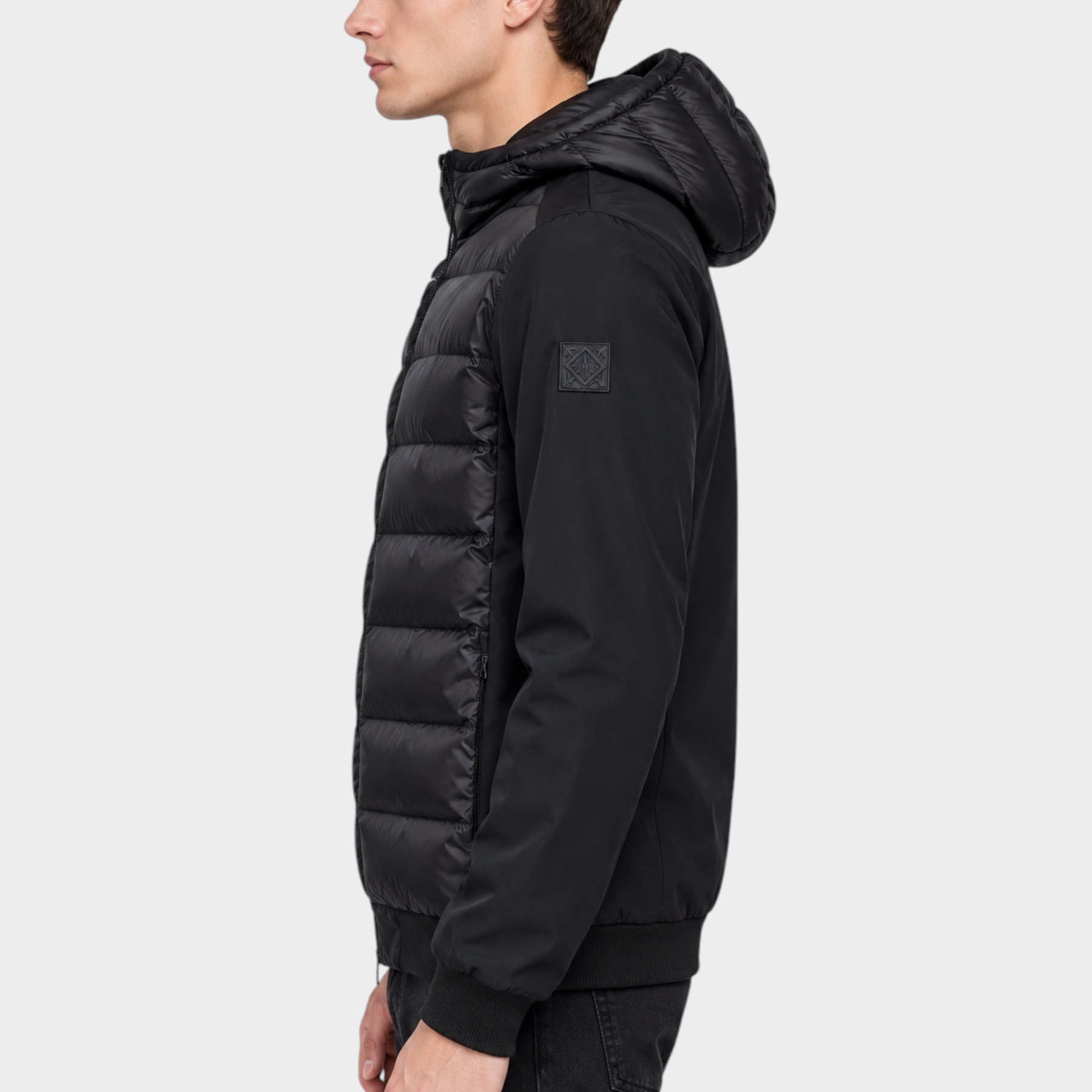 Giubbino Follower SRL HERO nero in piumino e nylon con cappuccio indossato da un modello di profilo