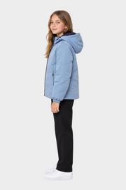 Ragazza che indossa il giubbino reversibile unisex Follower SRL azzurro con cappuccio su sfondo bianco