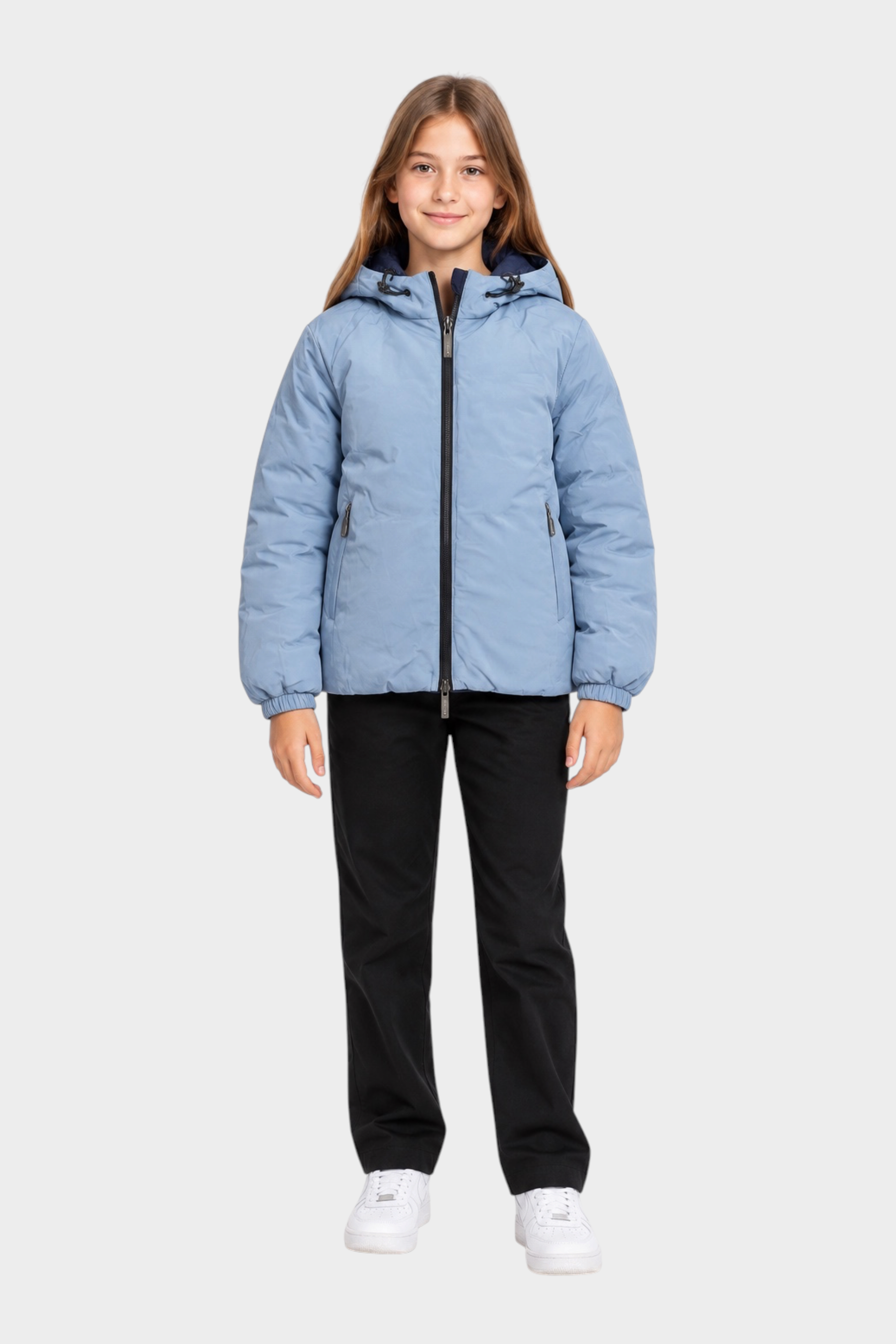 Ragazza indossa un giubbino reversibile Follower SRL azzurro con cappuccio e chiusura a zip su sfondo bianco