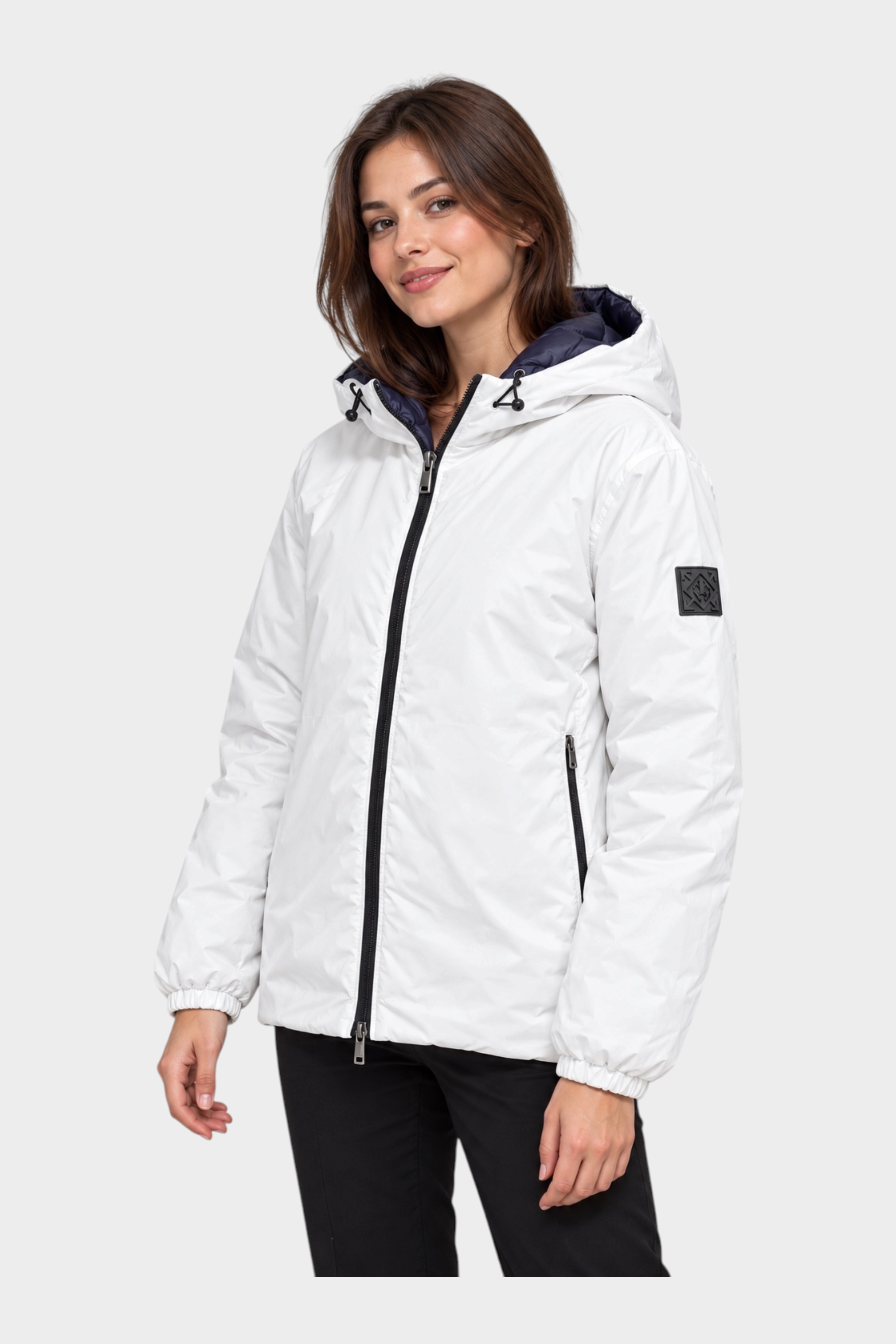 Modella indossa giubbino reversibile Follower SRL bianco con cappuccio, zip nera e logo sulla manica