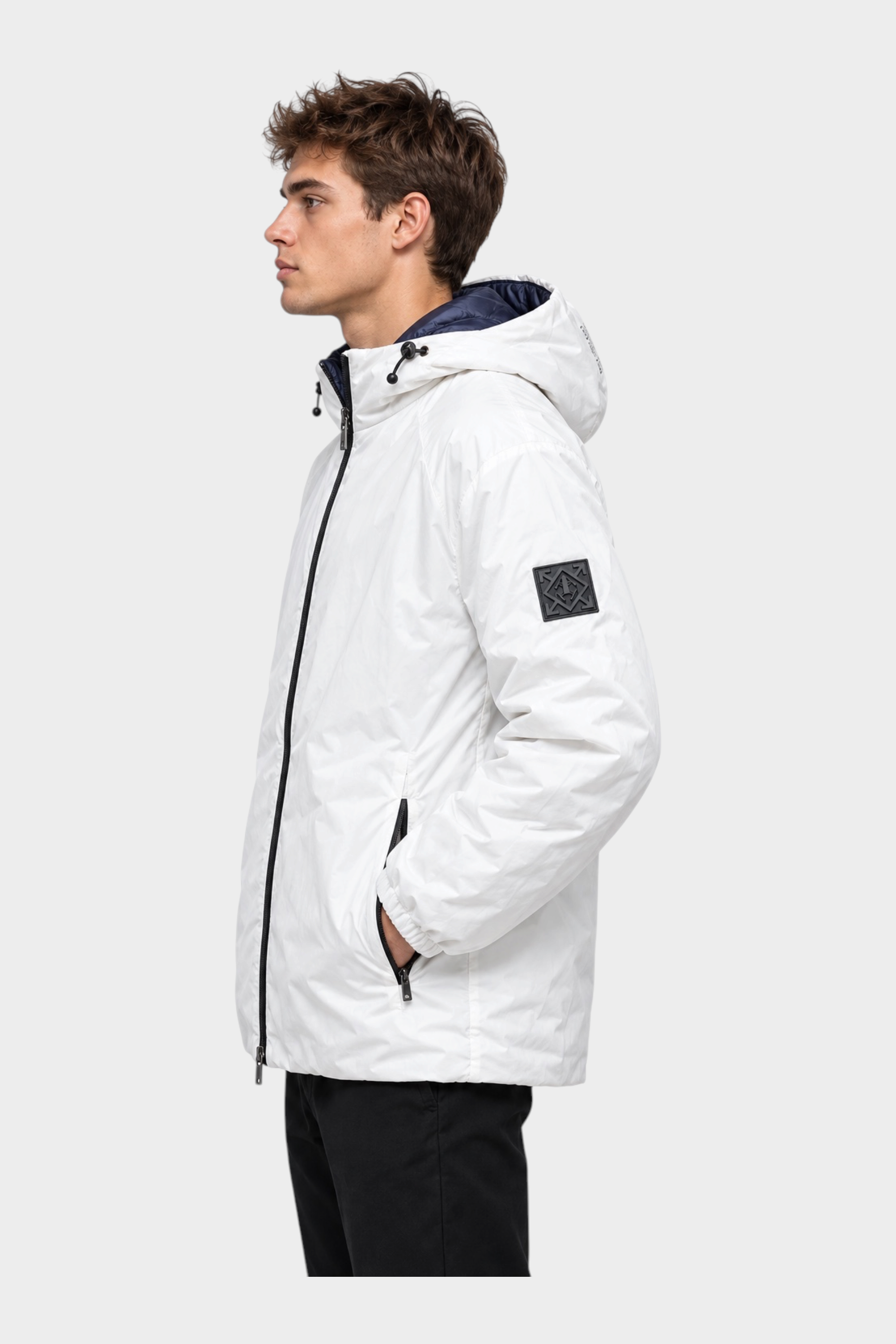 Modello indossa giubbino reversibile Follower SRL bianco con cappuccio e logo sulla manica, vista laterale