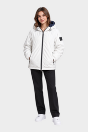 Modella indossa giubbino reversibile Follower SRL bianco con cappuccio e zip nera su pantaloni scuri