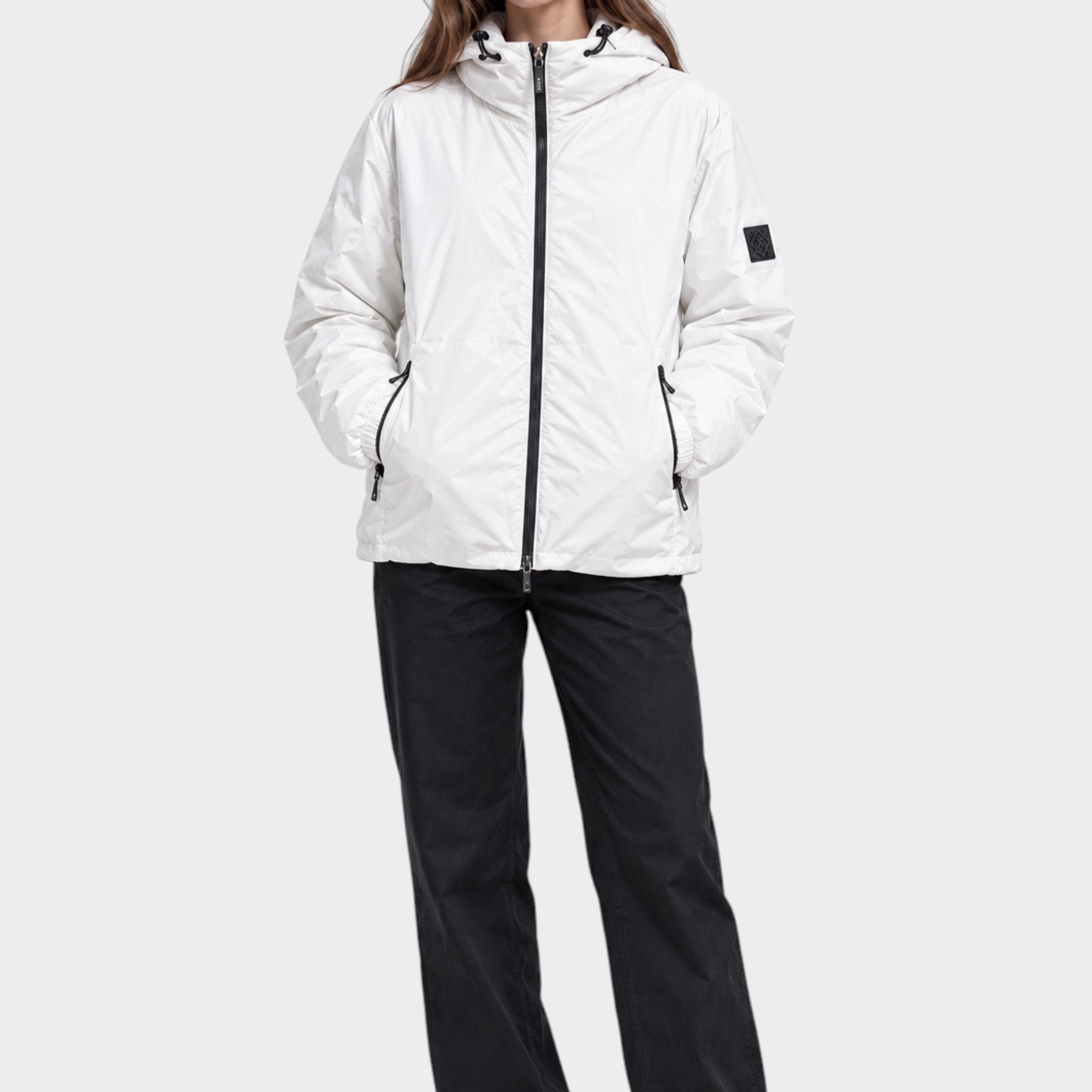Modella indossa giubbino reversibile Follower SRL bianco con cappuccio, zip nera e logo sulla manica, stile unisex