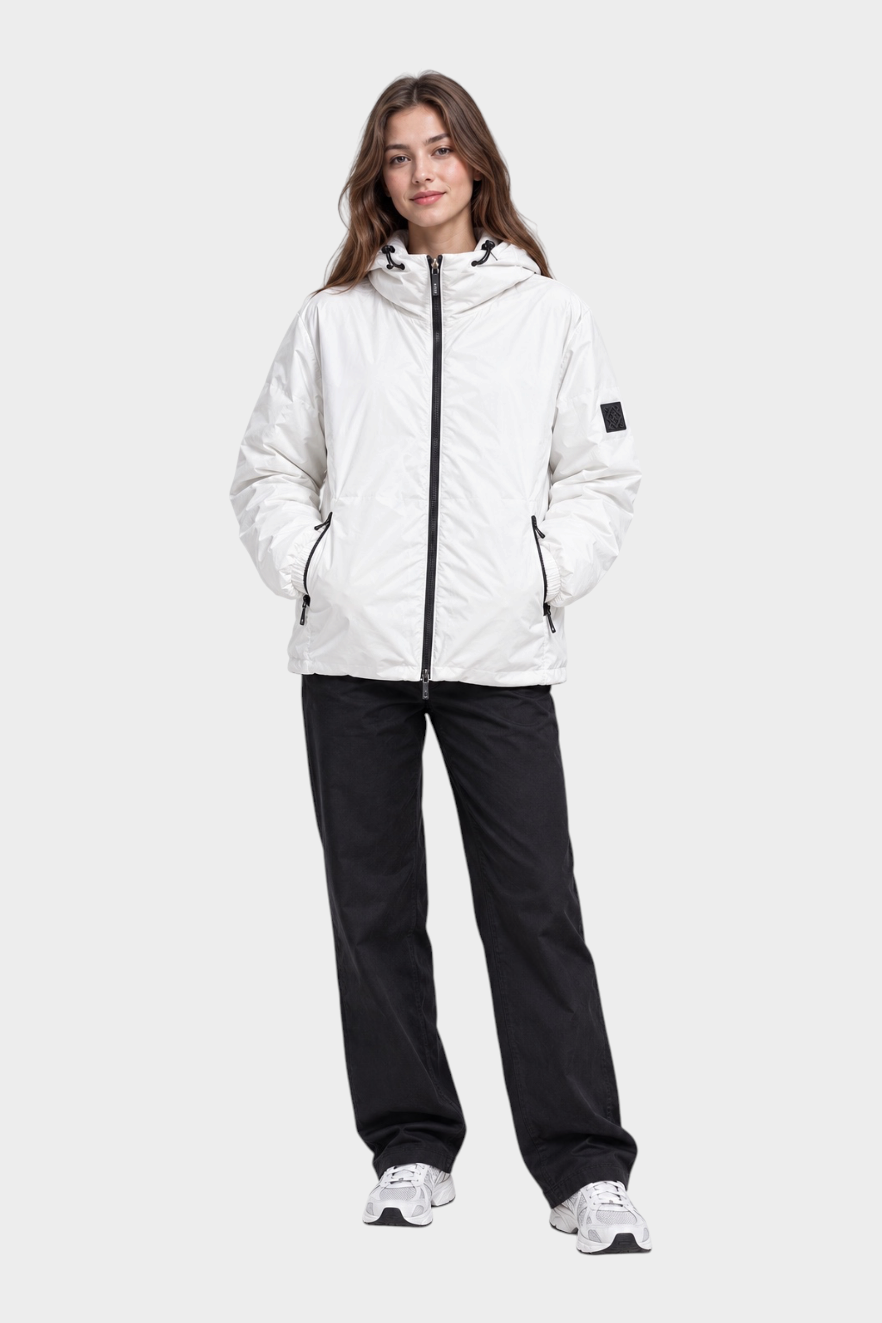 Modella indossa giubbino reversibile Follower SRL bianco con cappuccio, zip nera e logo sulla manica, stile unisex