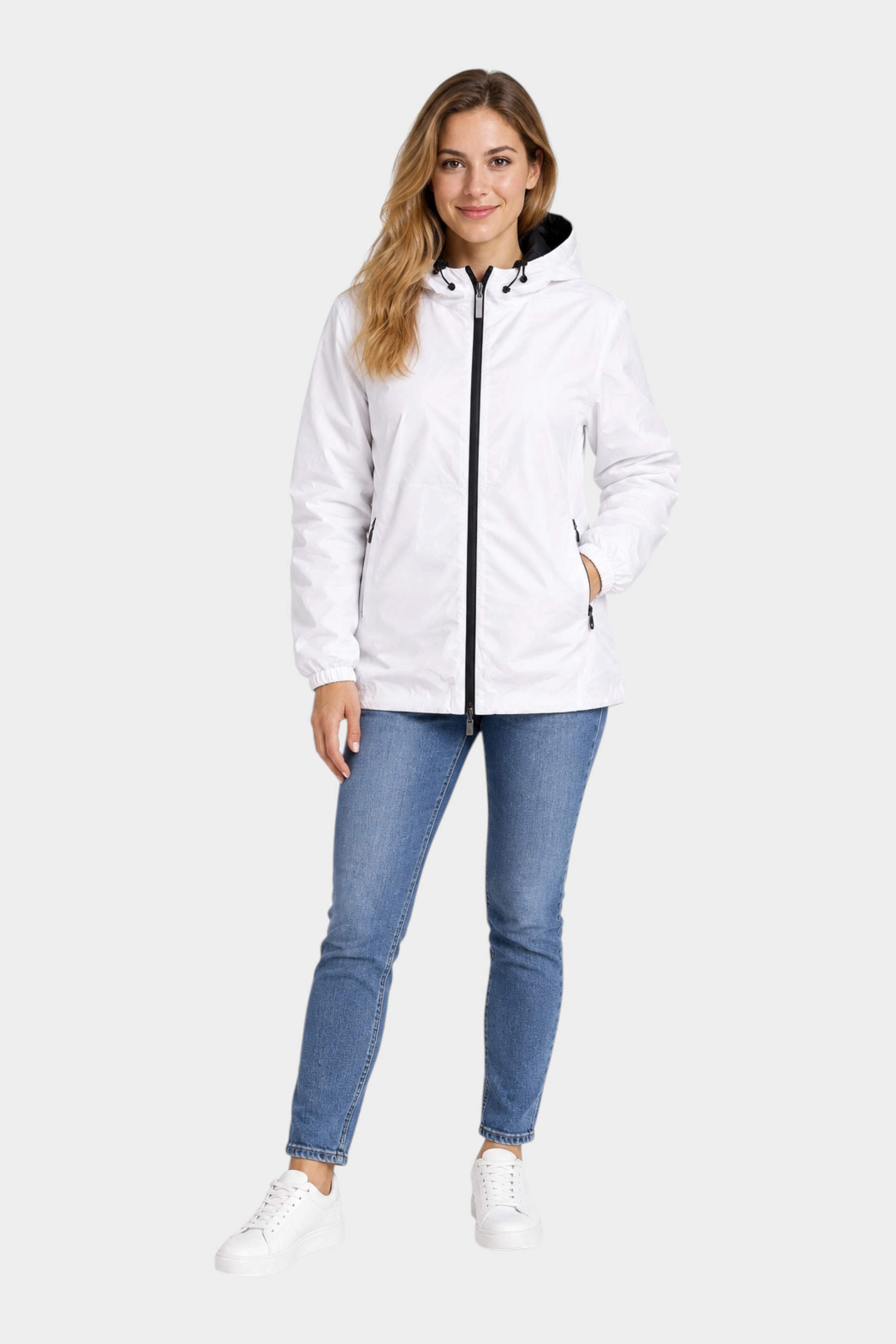 Modella indossa giubbino reversibile Follower SRL bianco con cappuccio e zip nera, abbinato a jeans blu