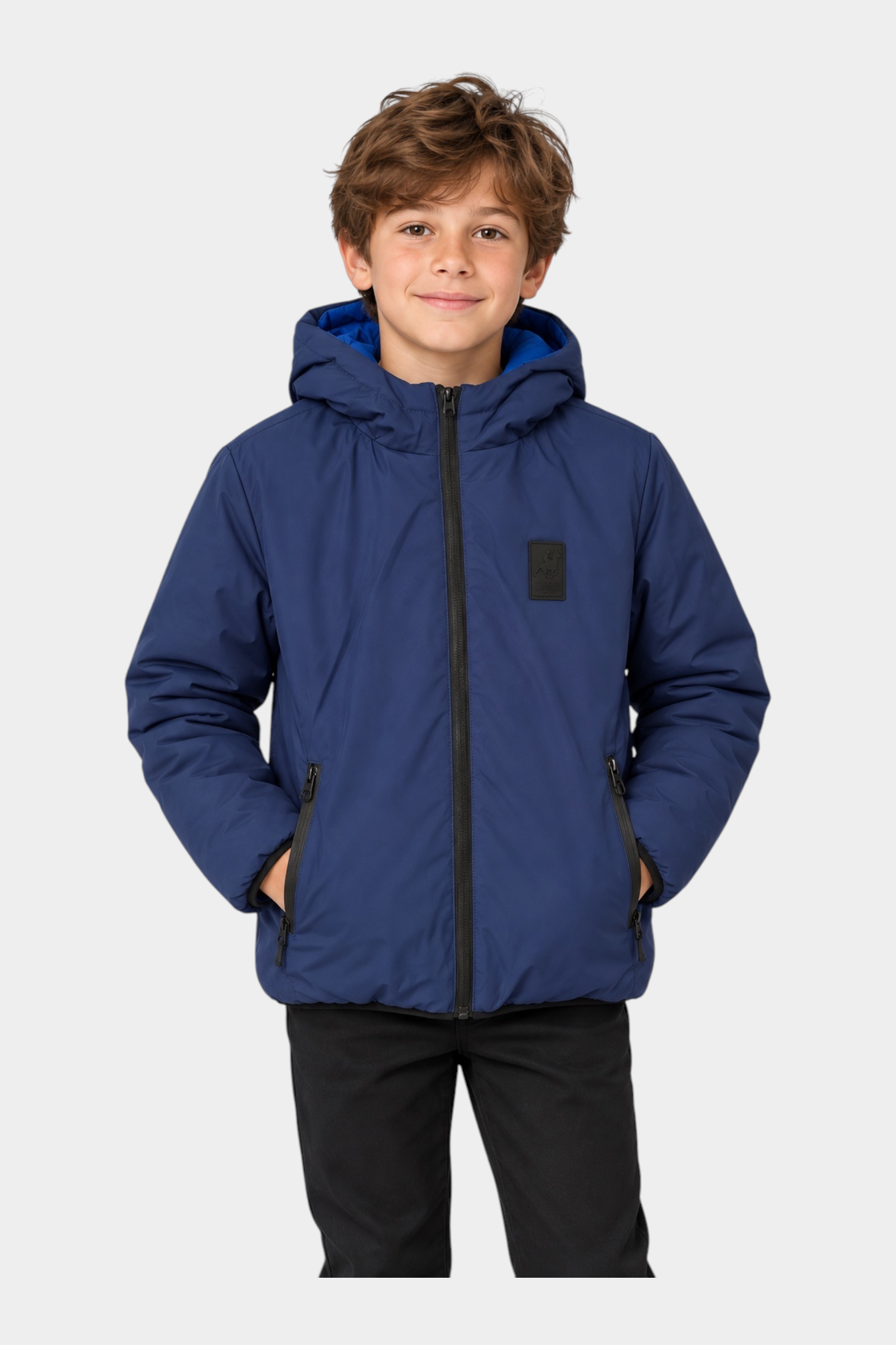 Ragazzo indossa un giubbino reversibile blu con cappuccio e zip nera, collezione Follower SRL