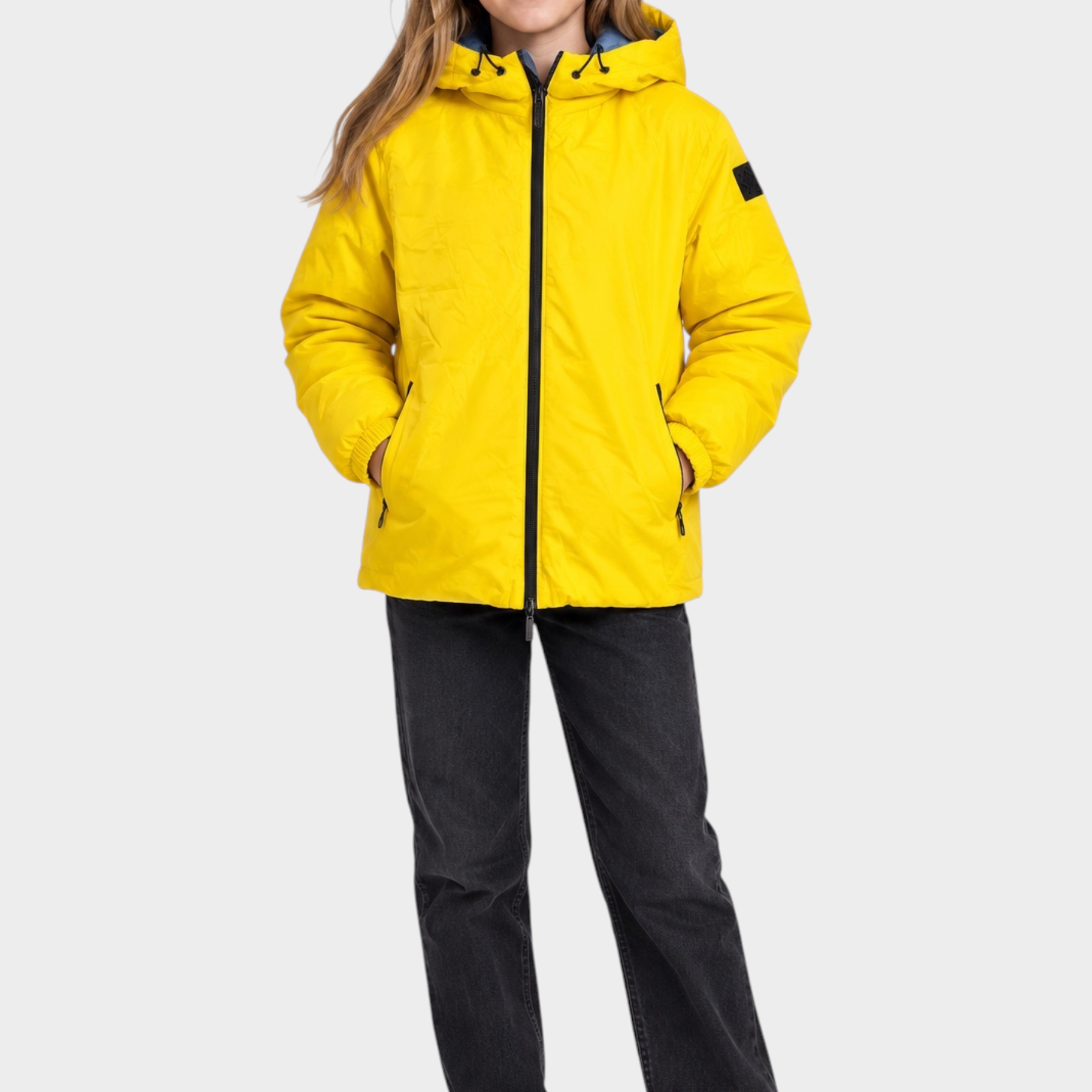 Ragazza indossa giubbino reversibile Follower SRL giallo con cappuccio e zip nera su sfondo neutro