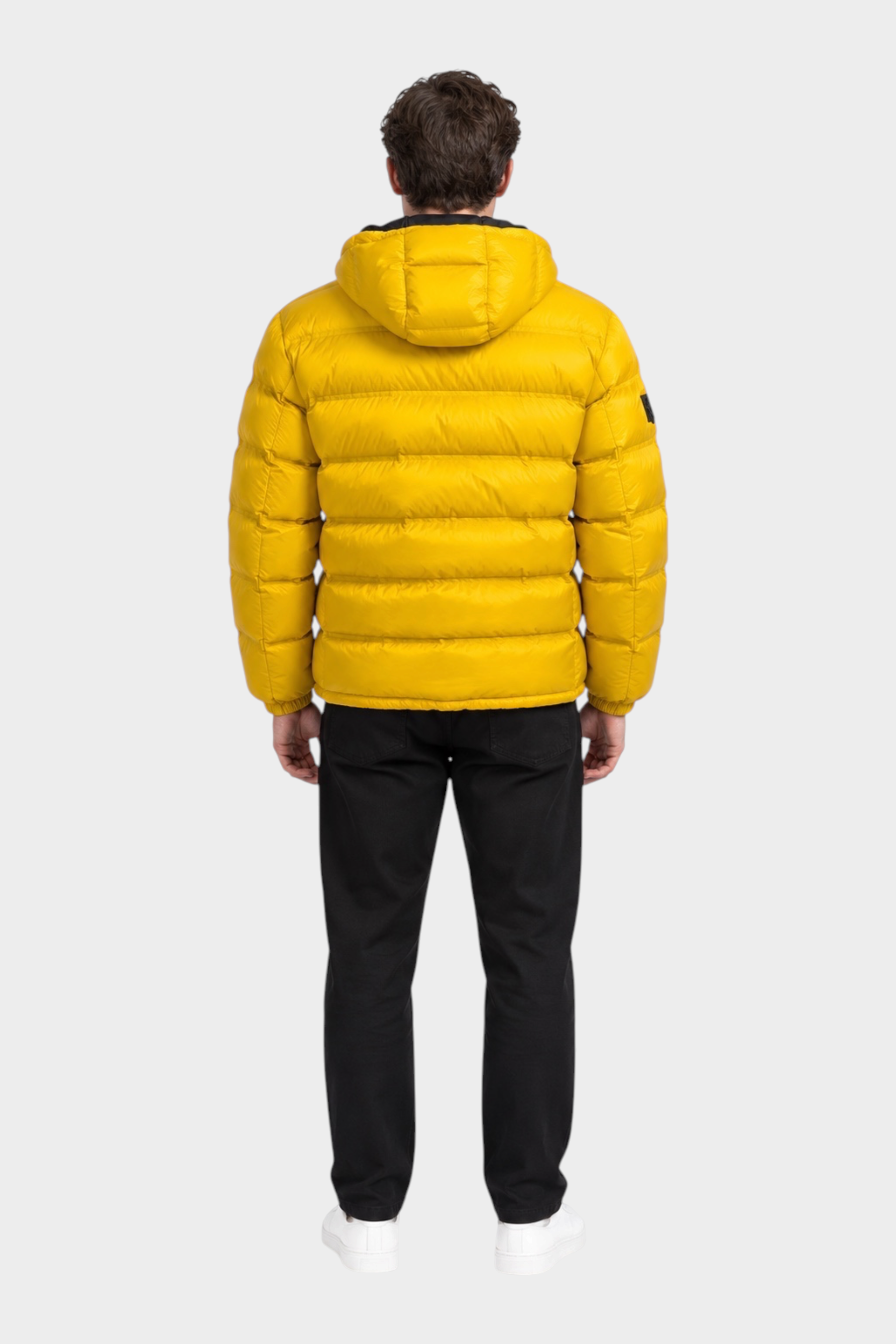 Giubbino reversibile Follower SRL giallo trapuntato con cappuccio indossato da un uomo visto di schiena