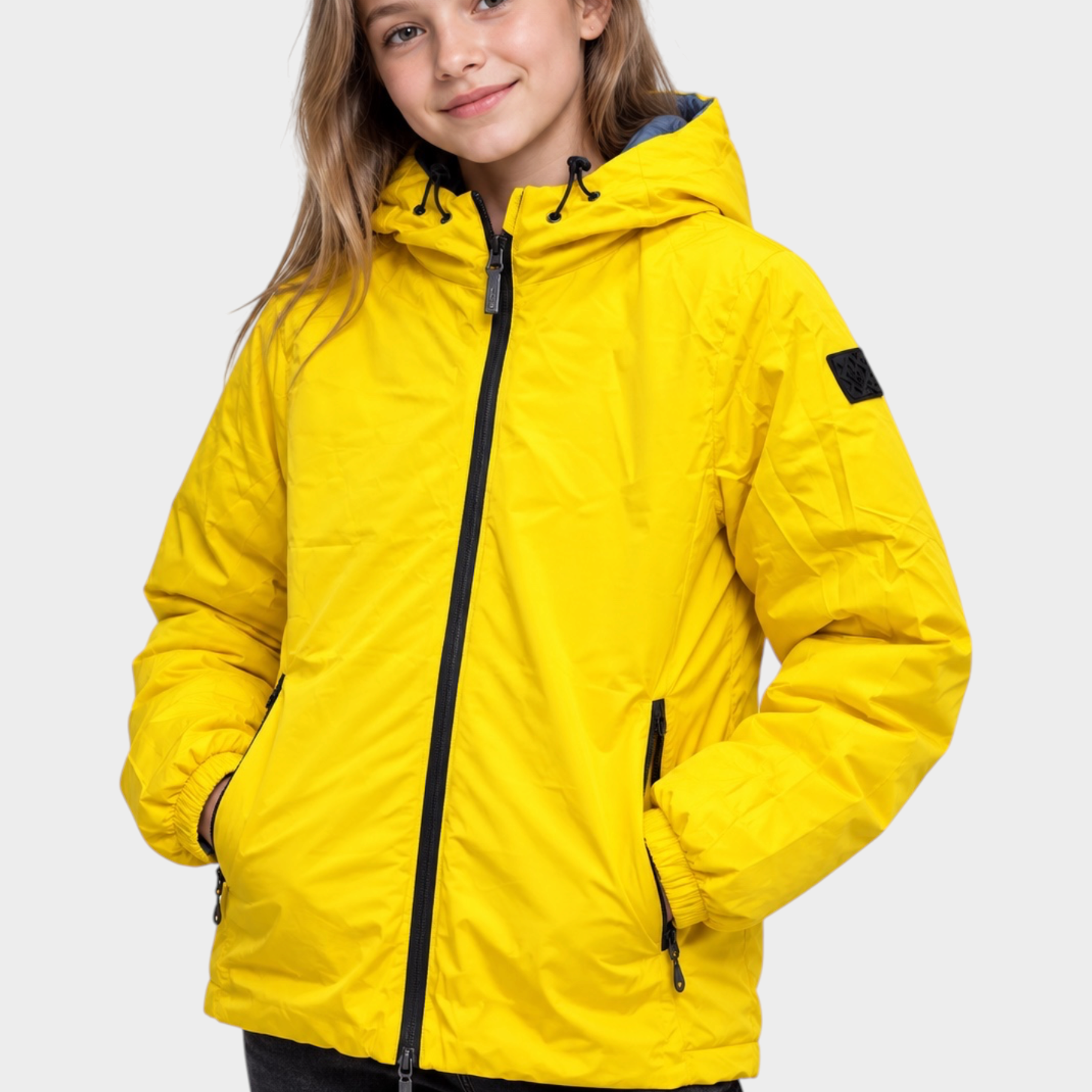 Ragazza che indossa un giubbino reversibile Follower SRL giallo con cappuccio e chiusura a zip nera