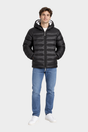 Modello indossa giubbino reversibile nero Follower SRL con cappuccio e imbottitura trapuntata su jeans blu