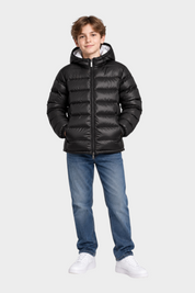 Ragazzo indossa giubbino reversibile nero Follower SRL con cappuccio e zip, abbinato a jeans blu e scarpe bianche