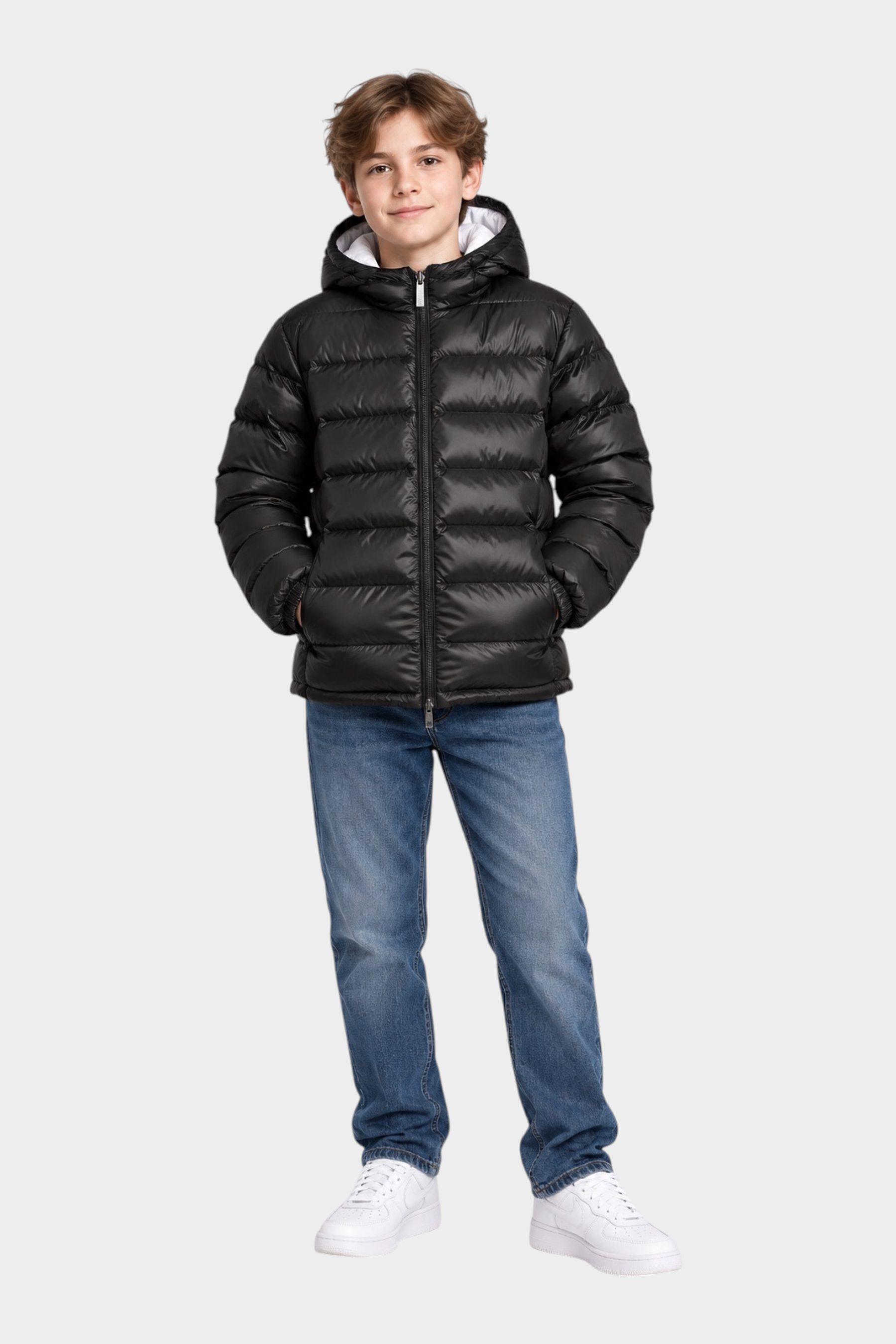Ragazzo indossa giubbino reversibile nero Follower SRL con cappuccio e zip, abbinato a jeans blu e scarpe bianche