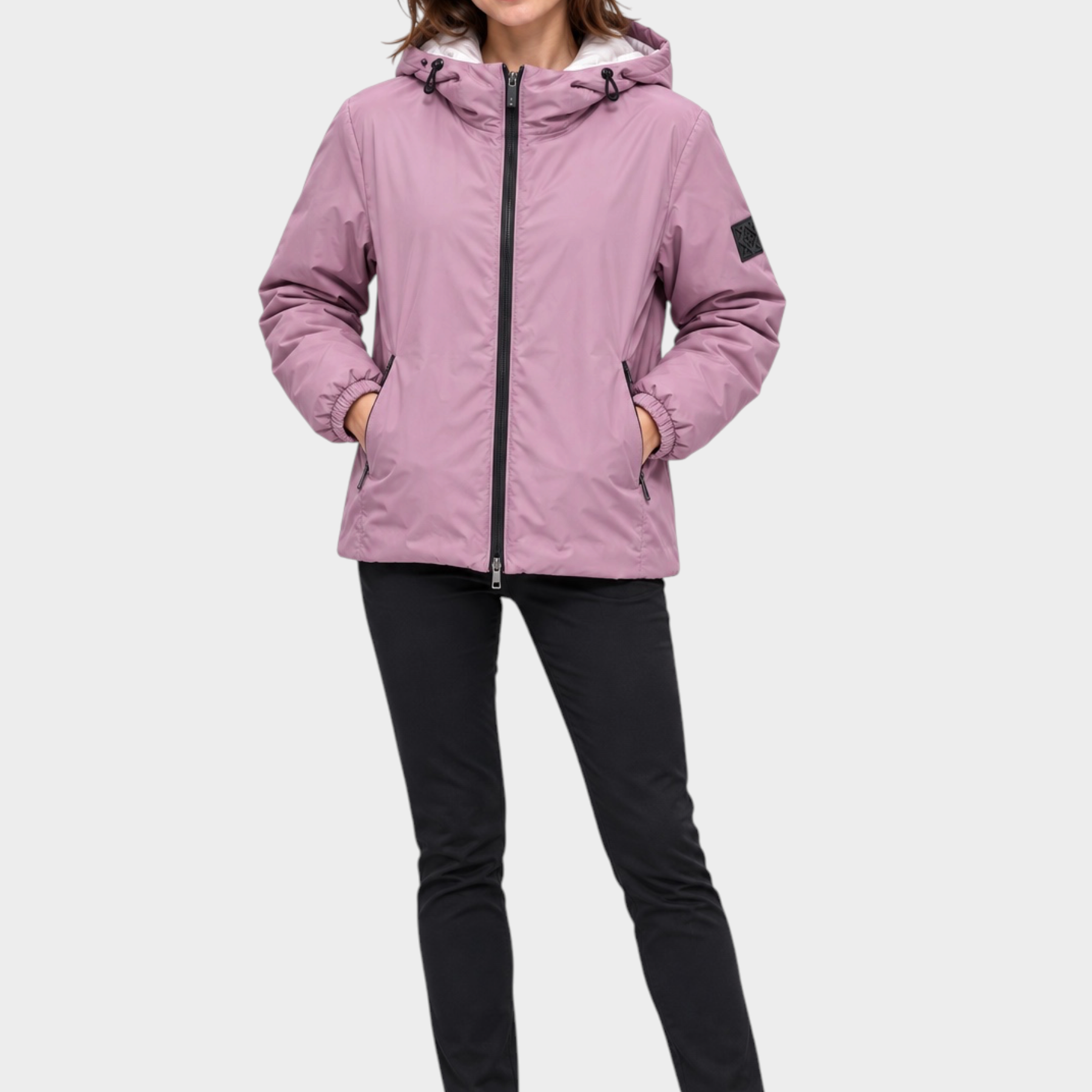Modella indossa giubbino reversibile Follower SRL rosa con cappuccio, zip nera e tasche laterali su sfondo bianco