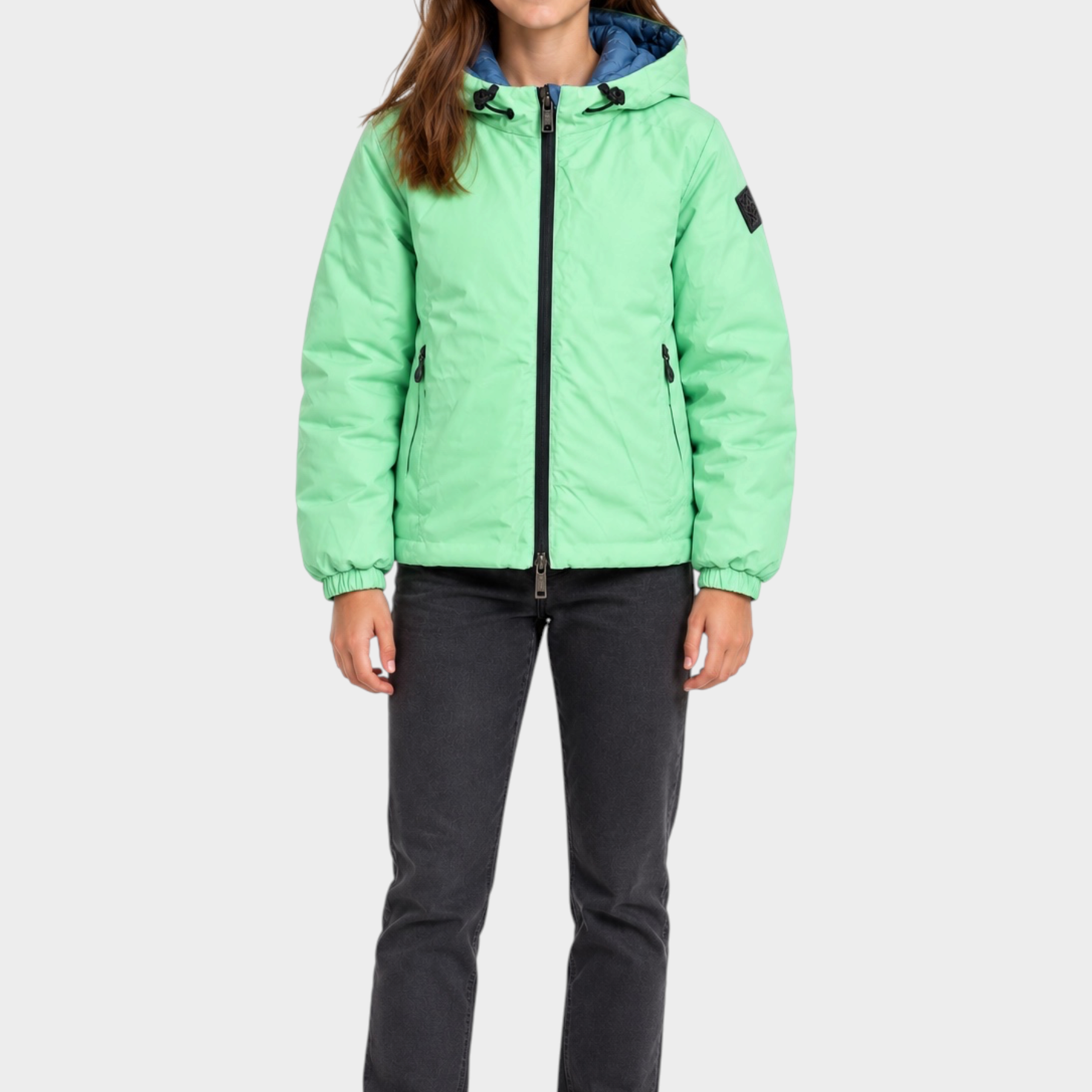 Ragazza indossa giubbino reversibile Follower SRL verde menta con cappuccio e zip nera su sfondo bianco