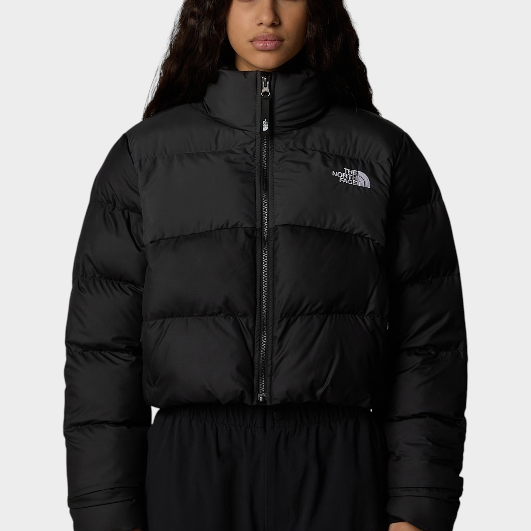 Modella indossa giubbino nero cropped Saikuru di Follower SRL con tecnologia WindWall e logo The North Face