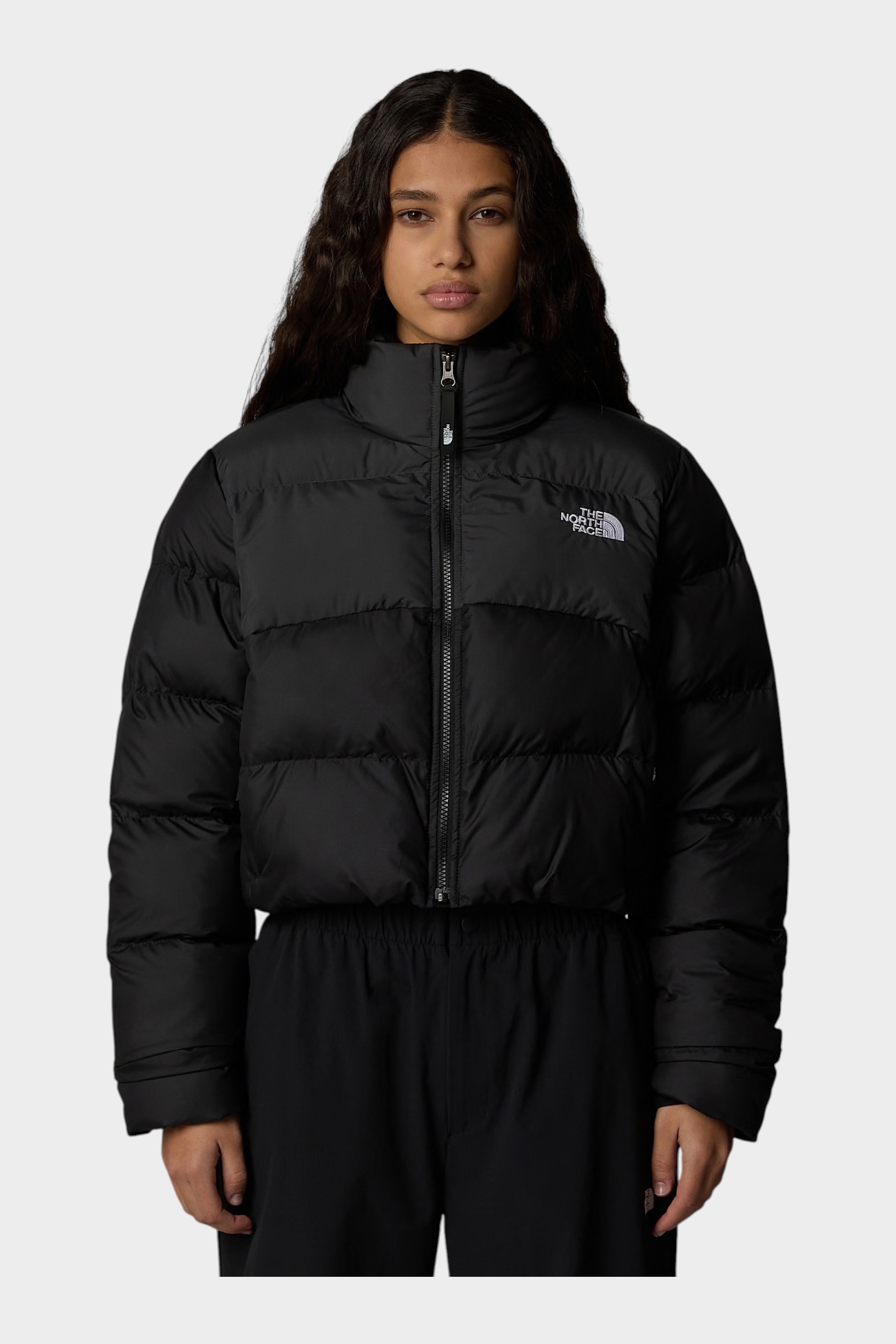 Modella indossa giubbino nero cropped Saikuru di Follower SRL con tecnologia WindWall e logo The North Face