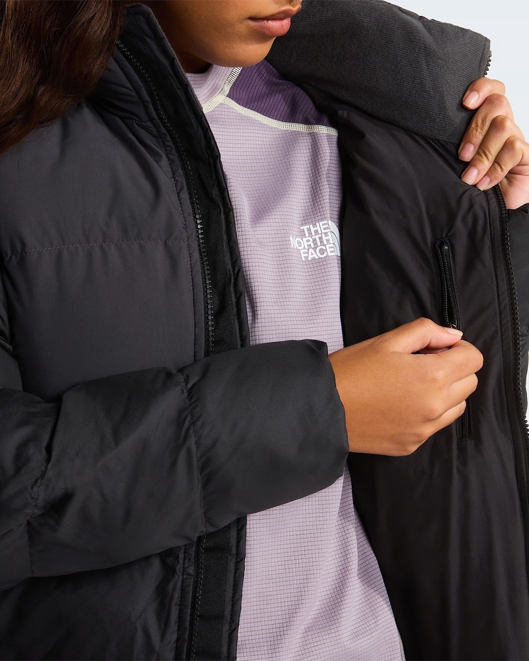 Dettaglio interno del giubbino nero Saikuru Donna di Follower SRL con cerniera e tasca, indossato sopra maglia viola
