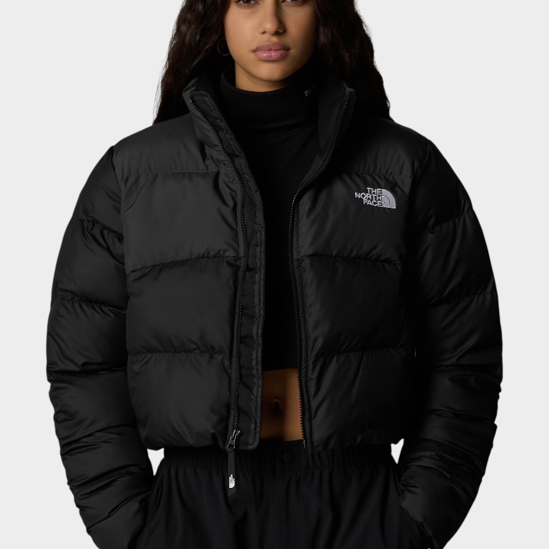 Modella indossa giubbino nero cropped Saikuru di Follower SRL con tecnologia WindWall e logo The North Face