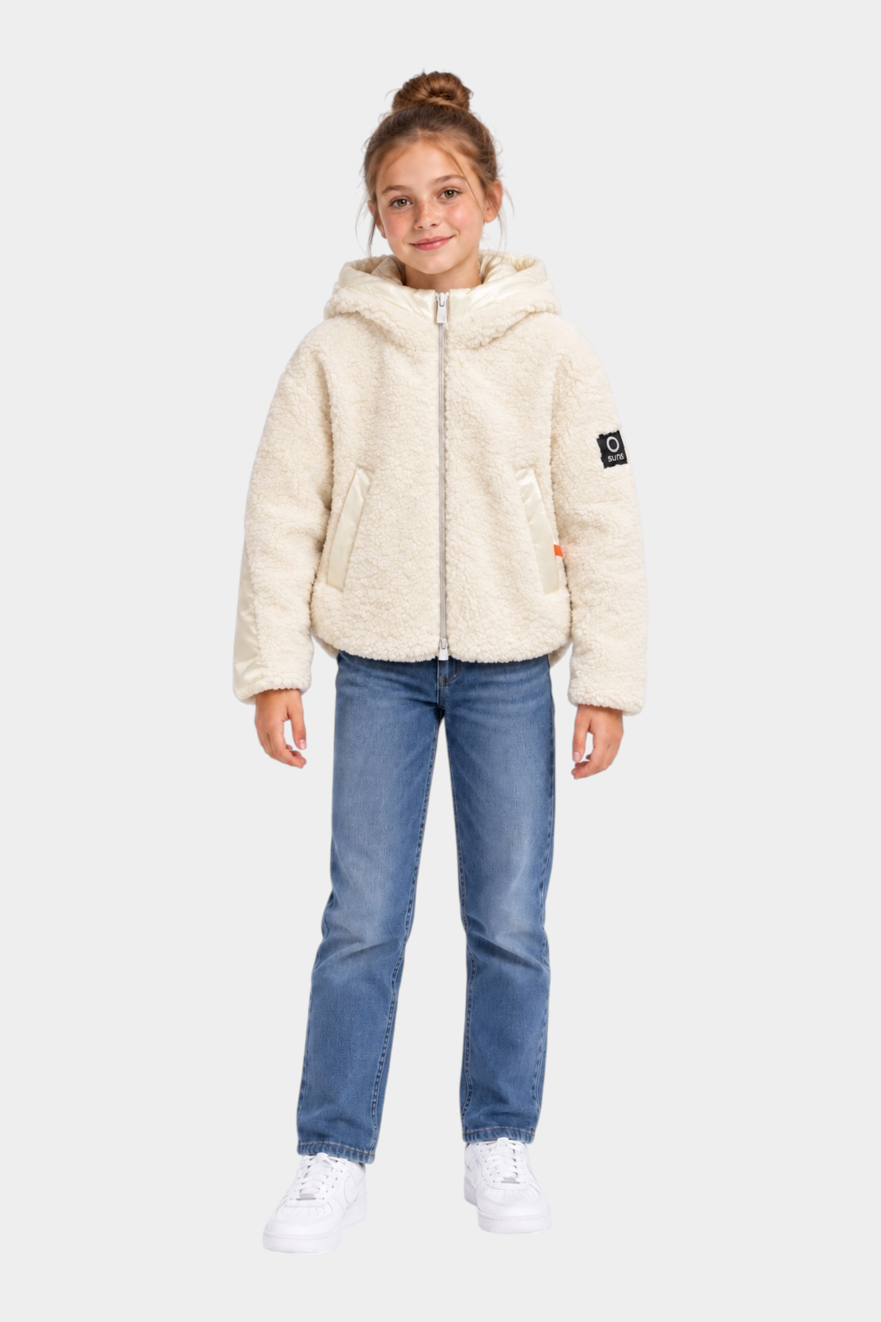 Bambina indossa giubbino teddy avorio con cappuccio e logo Follower SRL, abbinato a jeans blu e scarpe bianche