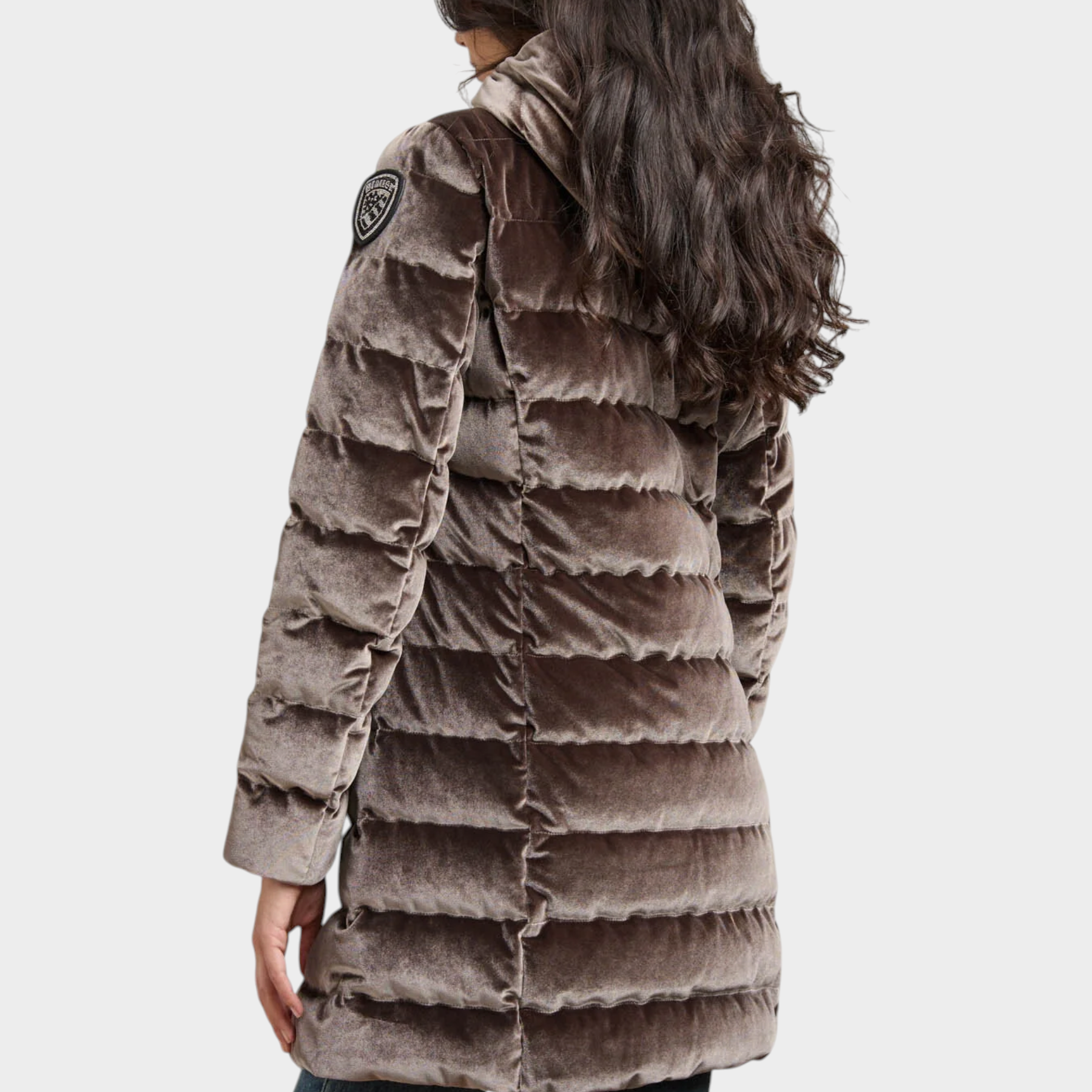 Modella di spalle indossa giubbino lungo trapuntato in velluto marrone lucido Follower SRL con logo Blauer sulla spalla