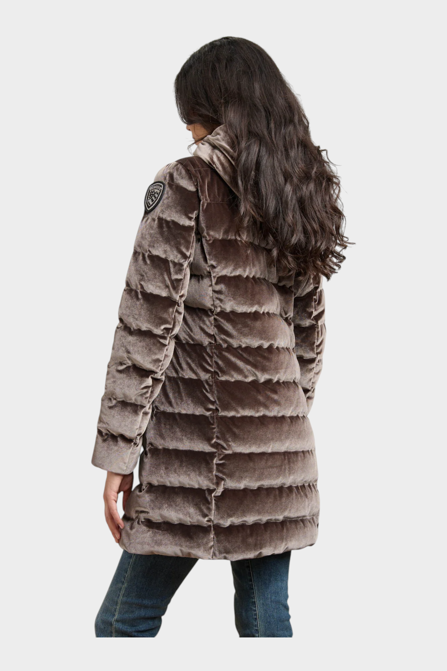 Modella di spalle indossa giubbino lungo trapuntato in velluto marrone lucido Follower SRL con logo Blauer sulla spalla