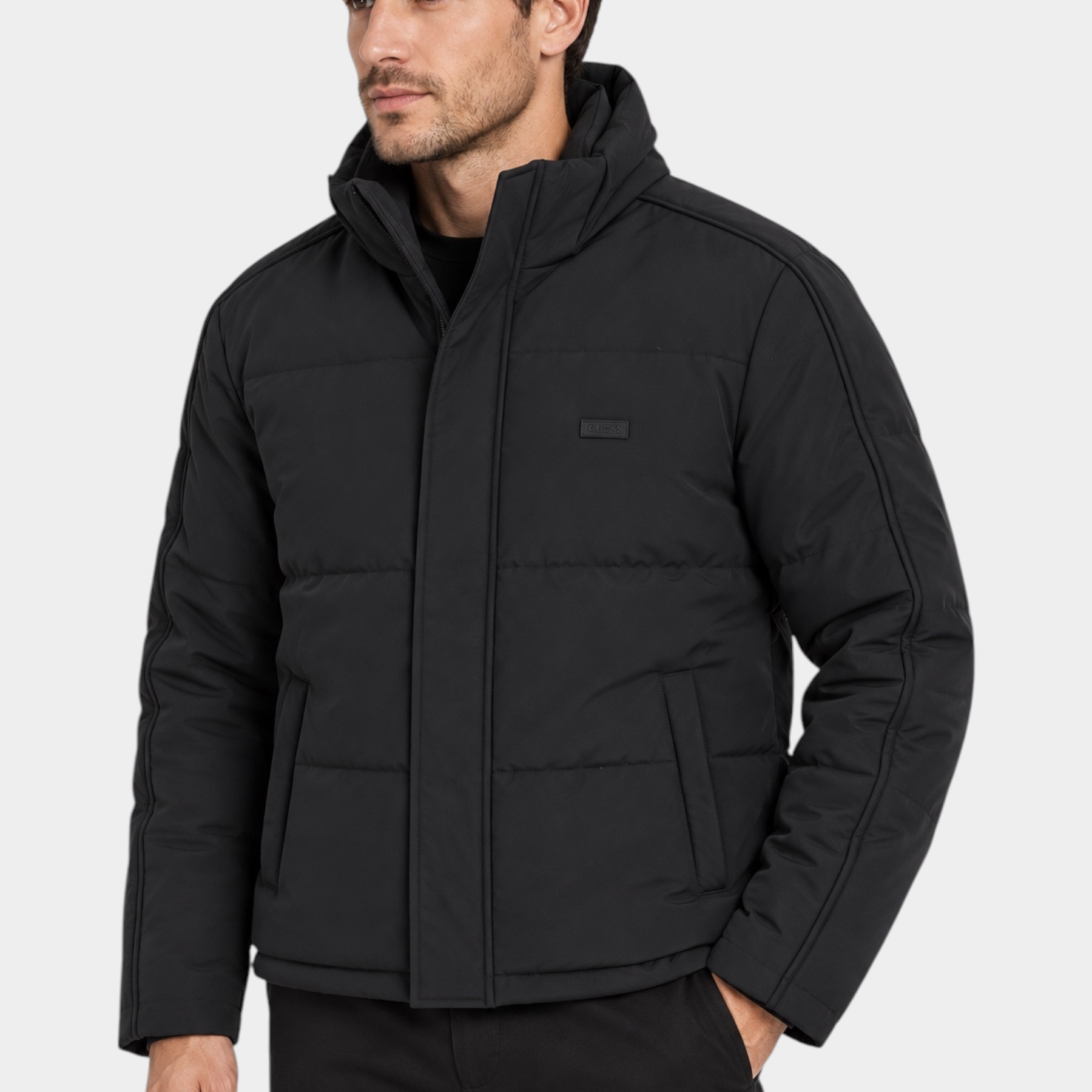 Modello indossa giubbotto imbottito nero Follower SRL con cappuccio e logo GUESS sul petto