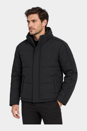 Modello indossa giubbotto imbottito nero Follower SRL con cappuccio e logo GUESS sul petto