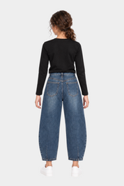 Jeans baggy blu con strass per bambina di Follower SRL, vista posteriore su modella con maglia nera e scarpe bianche