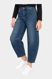 Bambina che indossa jeans baggy blu Follower SRL abbinati a una maglia nera a maniche lunghe con scritta bianca